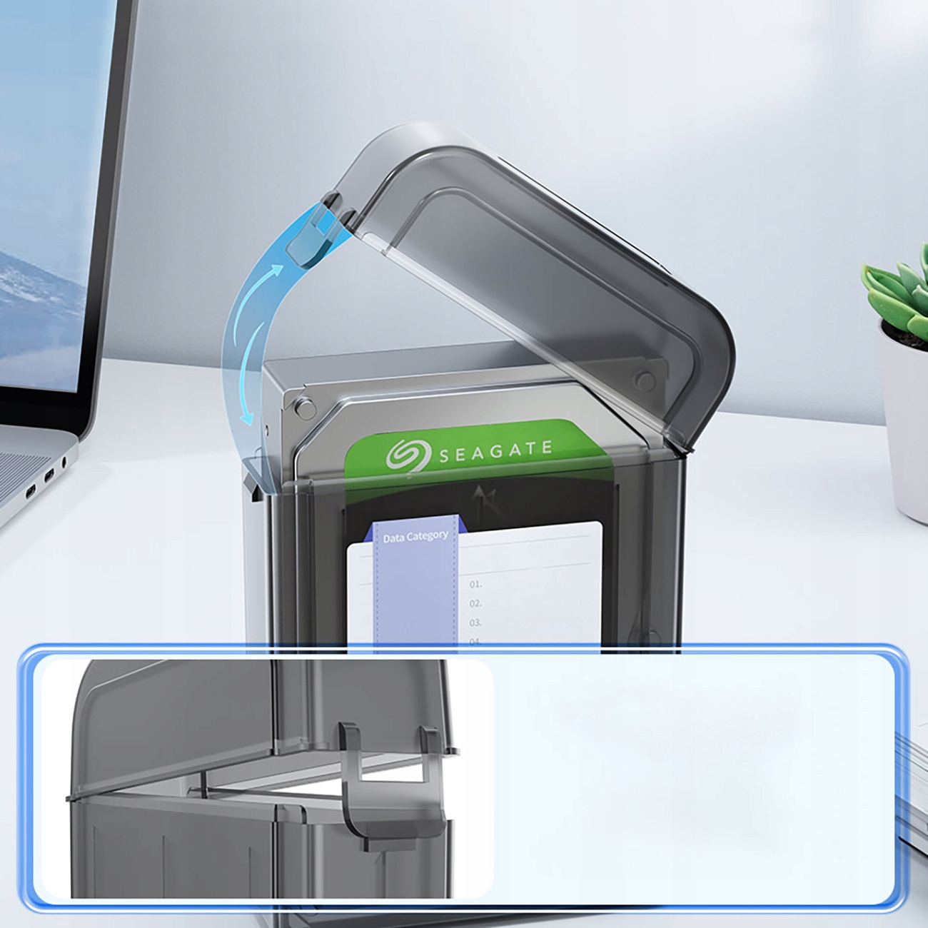 Dysk twardy w przezroczystej obudowie. Pokrywa otwarta, strzałki wskazują kierunek otwierania. Laptop w tle.