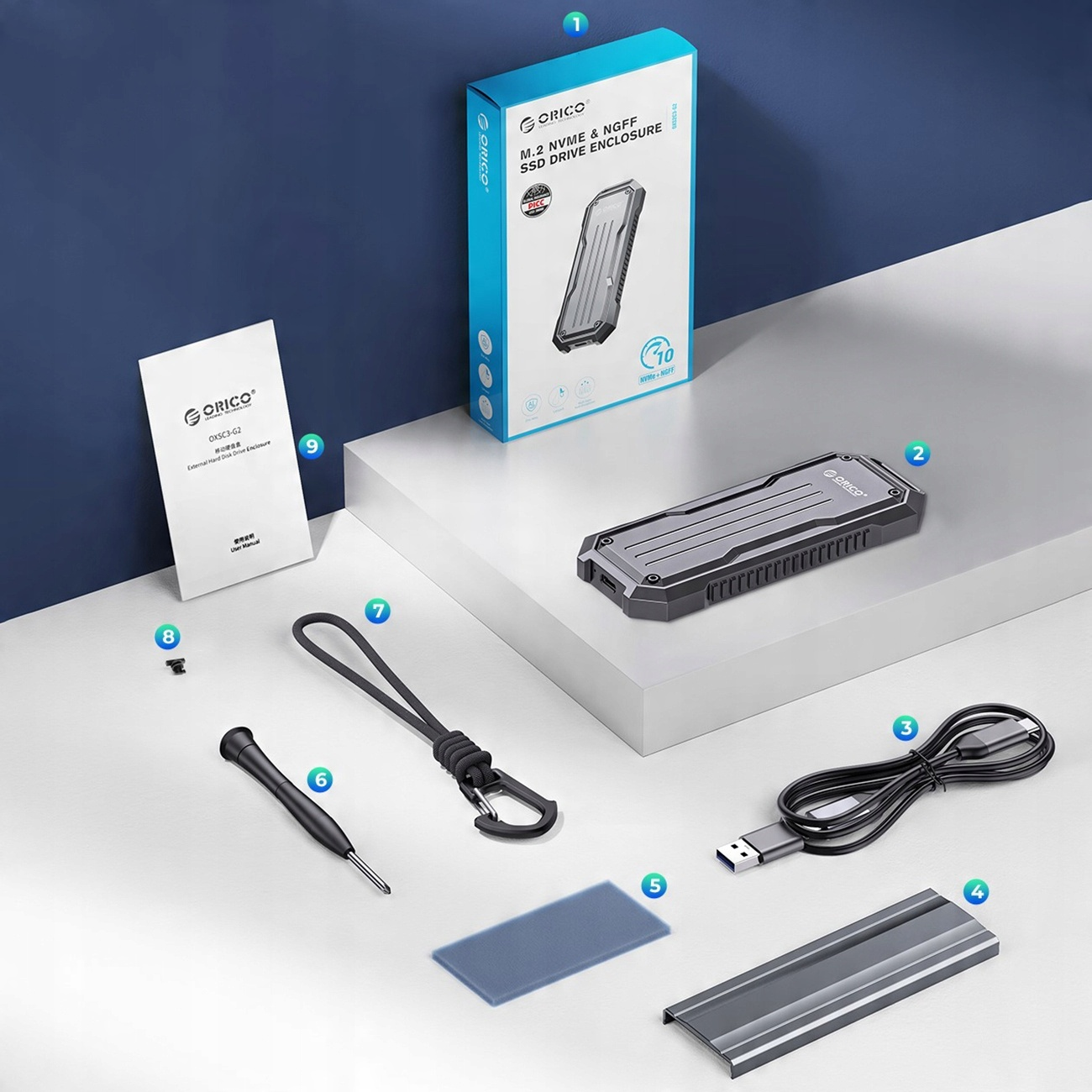 Różne komponenty komputera, w tym pudełko, obudowa dysku twardego, śrubokręt i kabel USB. Białe tło.