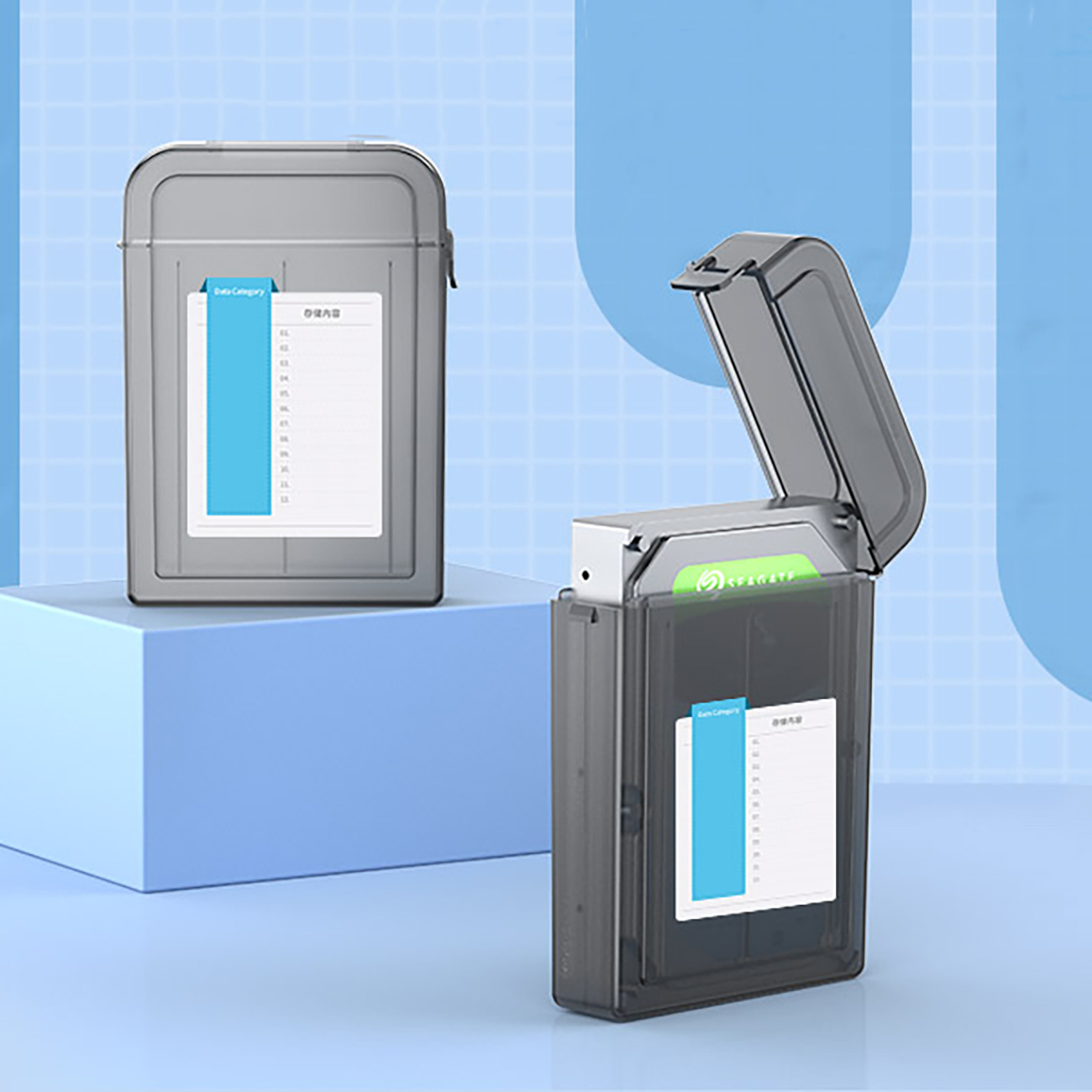 Dwa szare etui na dyski twarde. Jedno jest otwarte z etykietą w środku. Drugie jest zamknięte. Niebiesko-białe tło.