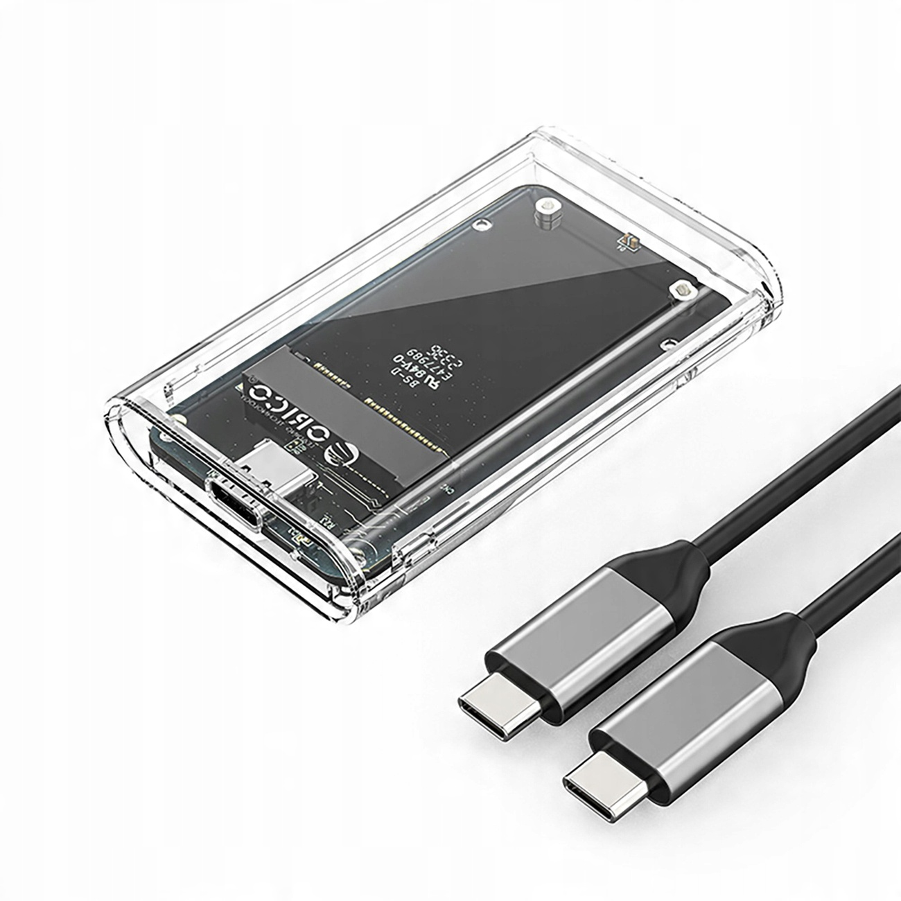 Przezroczysta obudowa z dyskiem SSD w środku i dwoma kablami USB-C, na białej powierzchni.