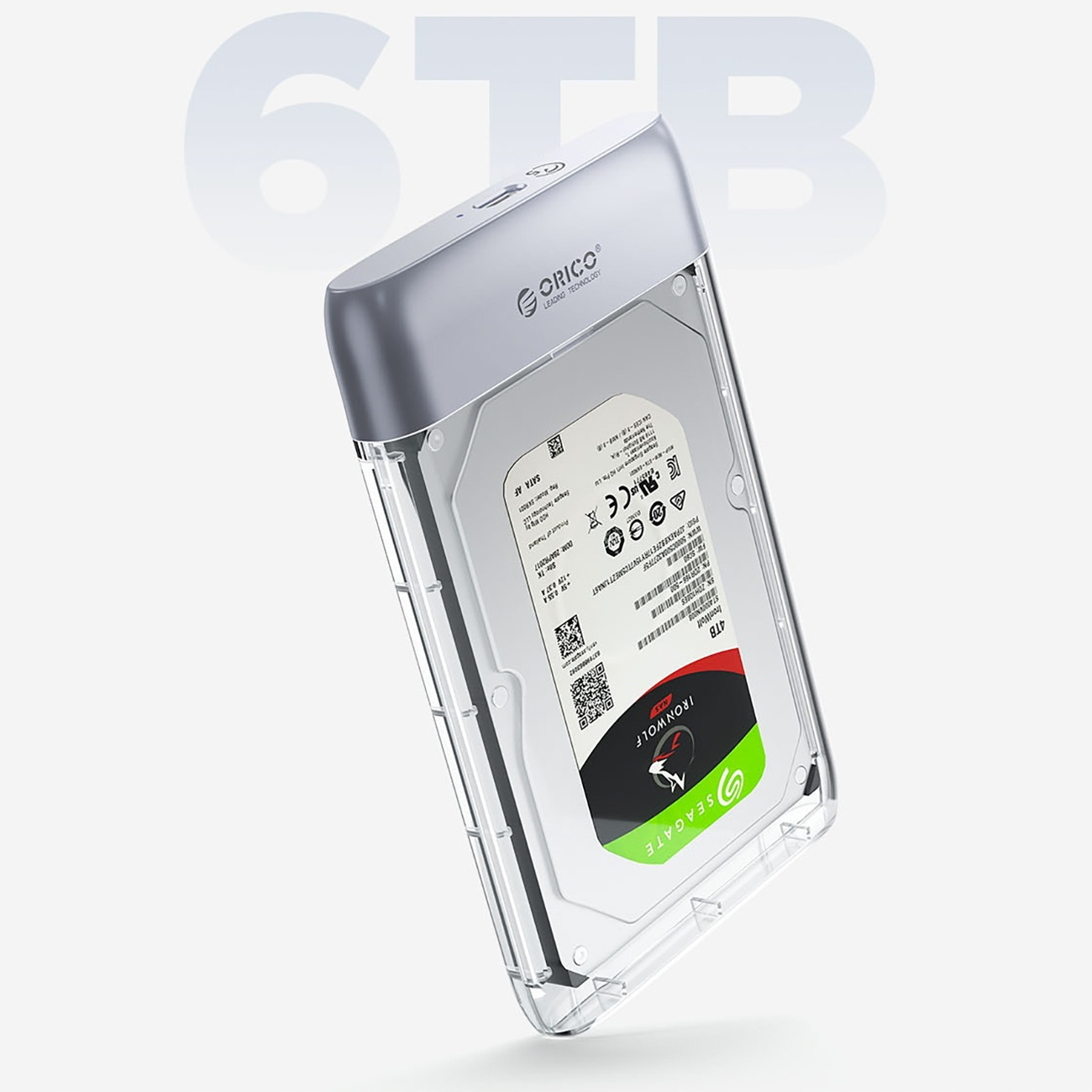 Dysk twardy w przezroczystej obudowie z szarą górą. U góry tekst '6TB'. Białe tło.