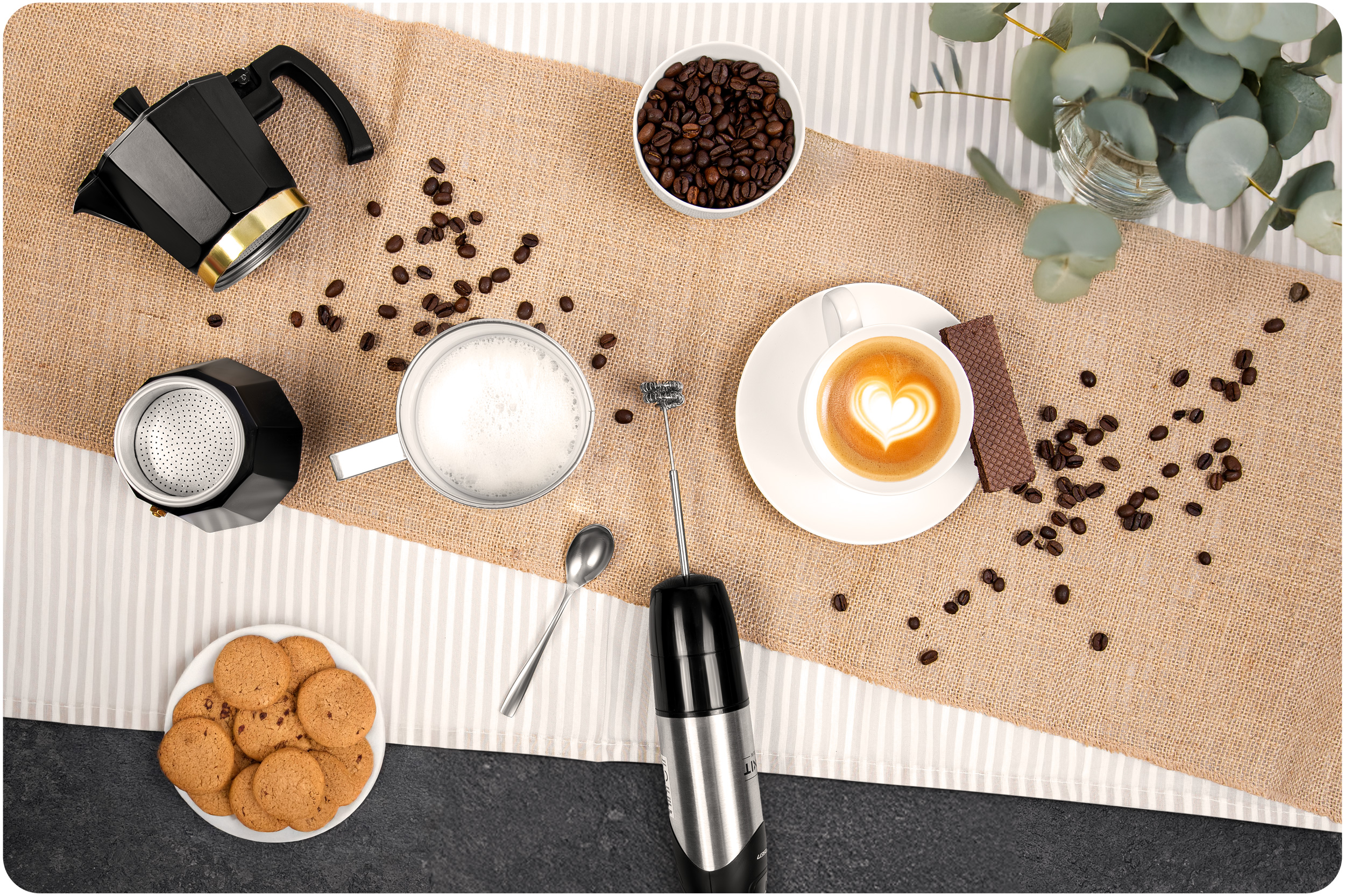 Kawa z ekspresem do kawy, ciastkami, kawą i spieniaczem do mleka.