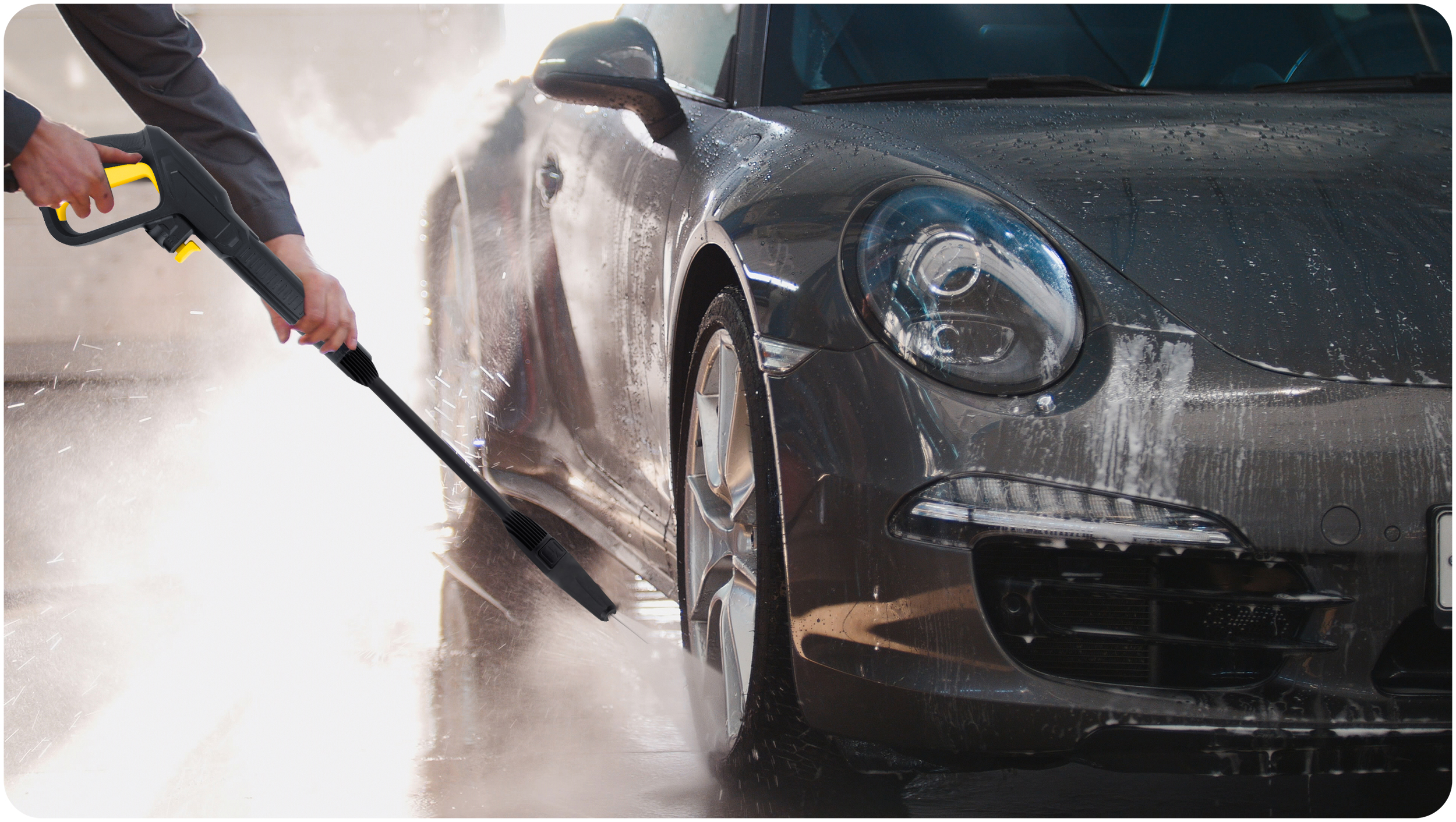 Osoba spryskuje szary samochód wodą za pomocą czarno-żółtej myjki ciśnieniowej, tworząc mgłę.