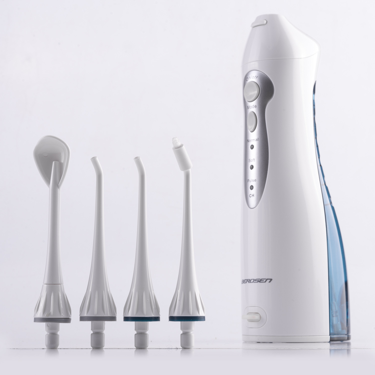 Biały irygator z czterema końcówkami po lewej stronie. Wszystko na białej powierzchni, białe tło.