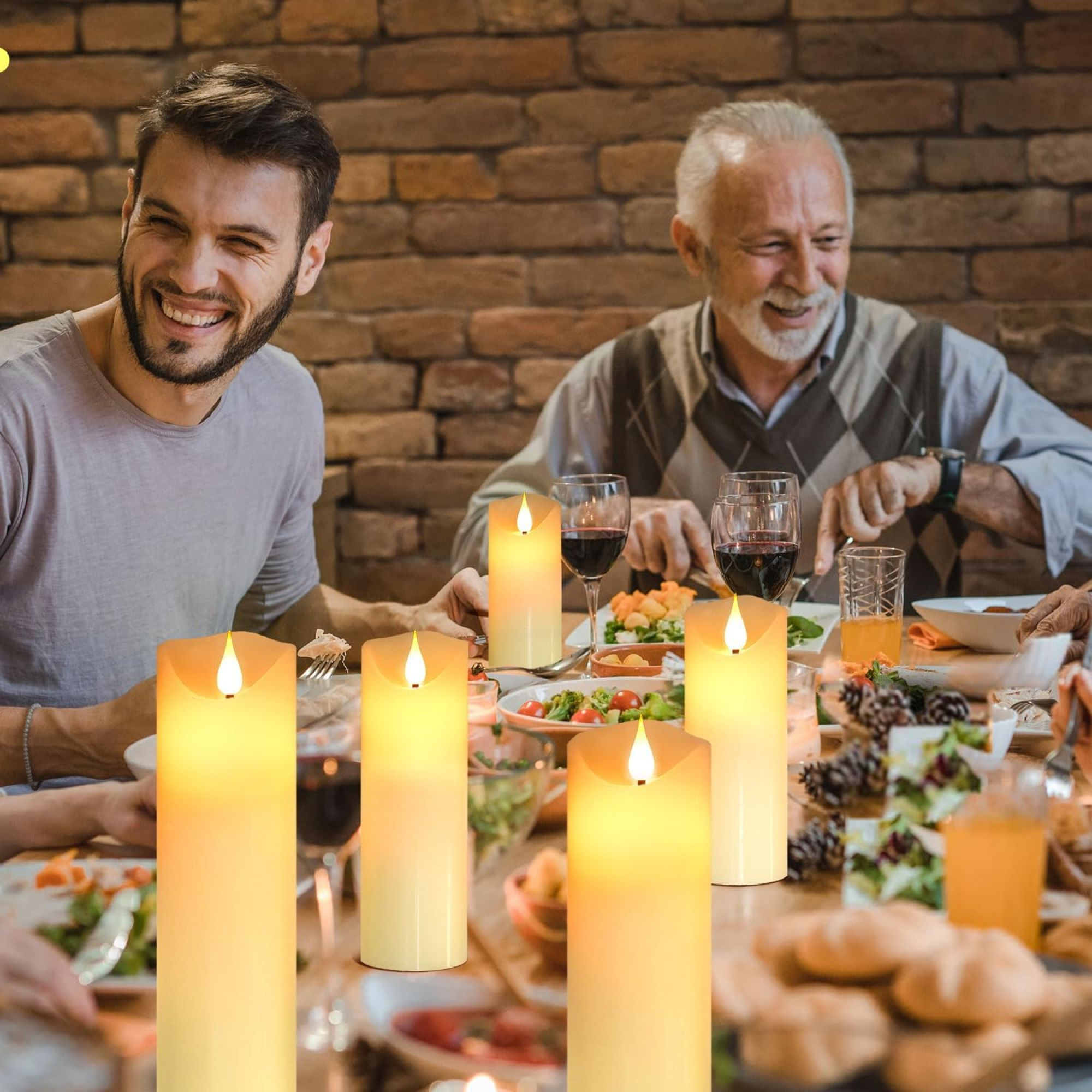Menschen versammeln sich um einen Tisch mit brennenden Kerzen. Es ist ein Abendessen.