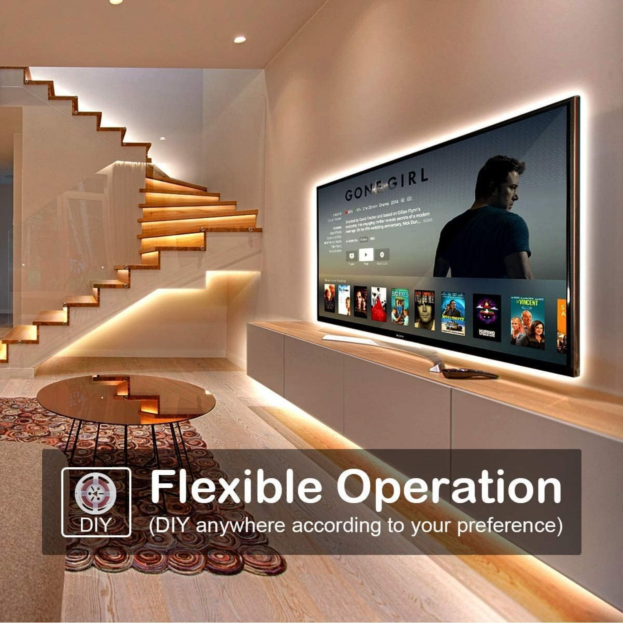 Ein Wohnzimmer mit einem Fernseher an der Wand, beleuchtet von LED-Streifenlichtern.