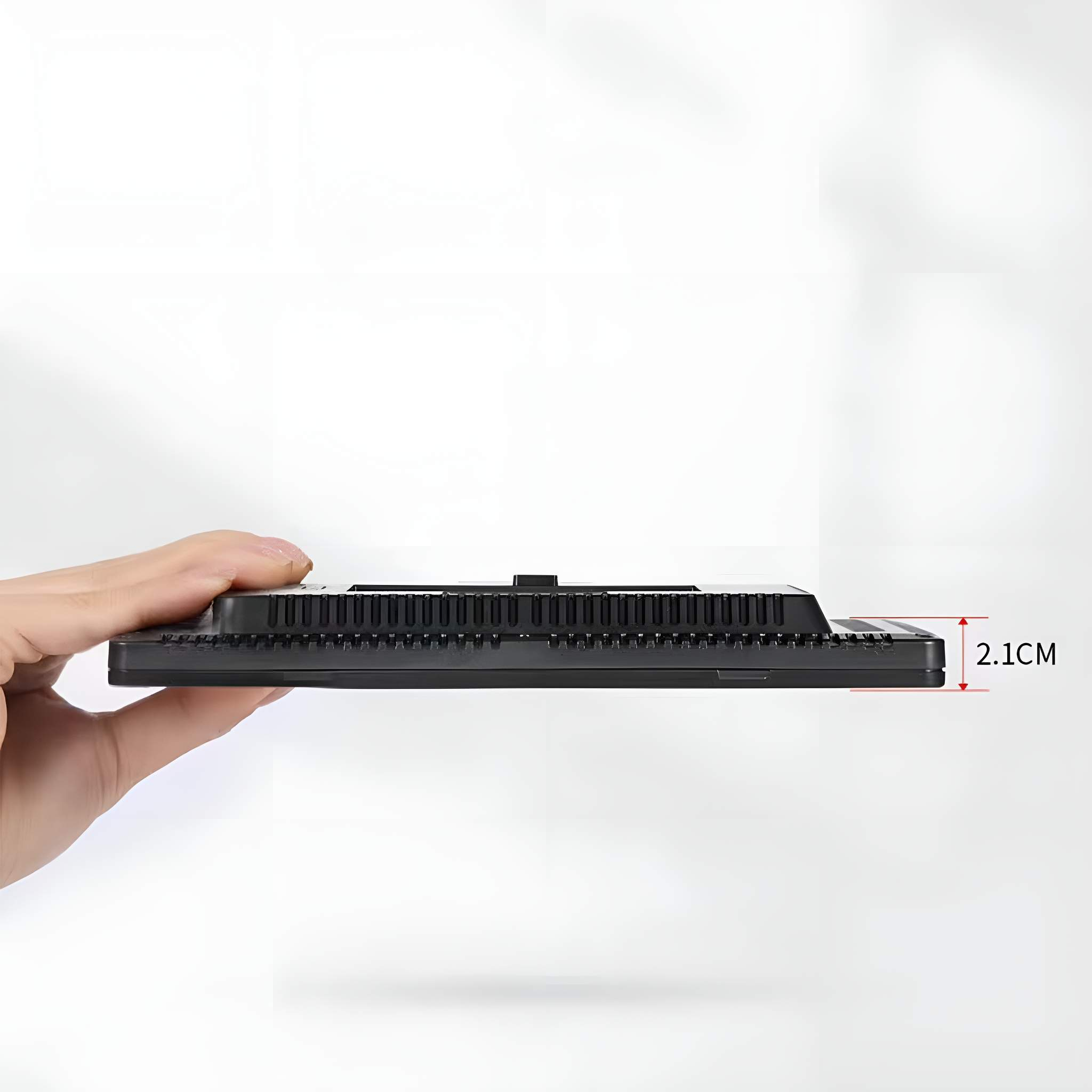 Seitenansicht eines schwarzen LED-Panels, die Dicke beträgt 2,1 cm, gehalten von einer Hand.