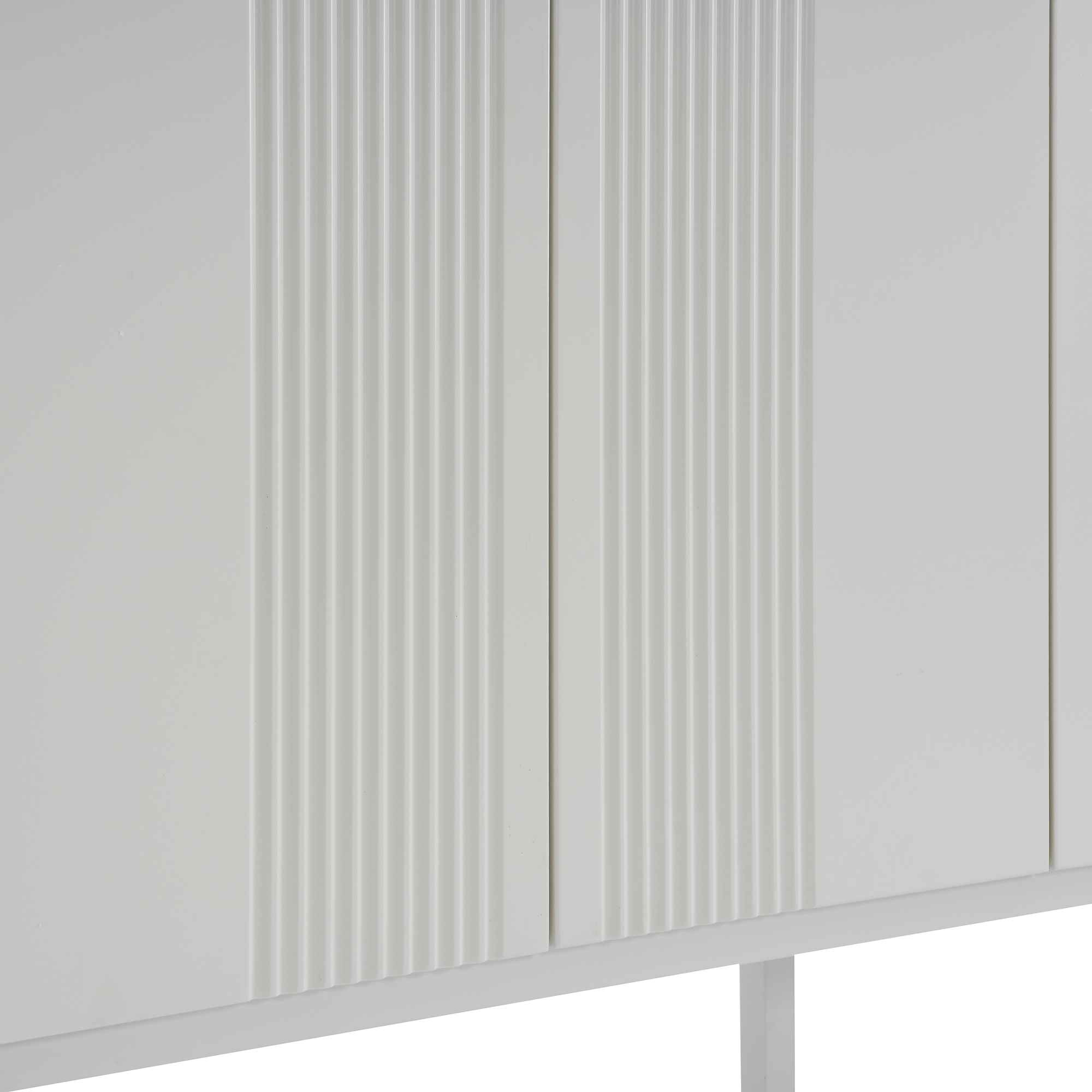 Nahaufnahme der Vorderseite eines weißen Sideboards mit vertikalen Rillen, die die Textur zeigen.