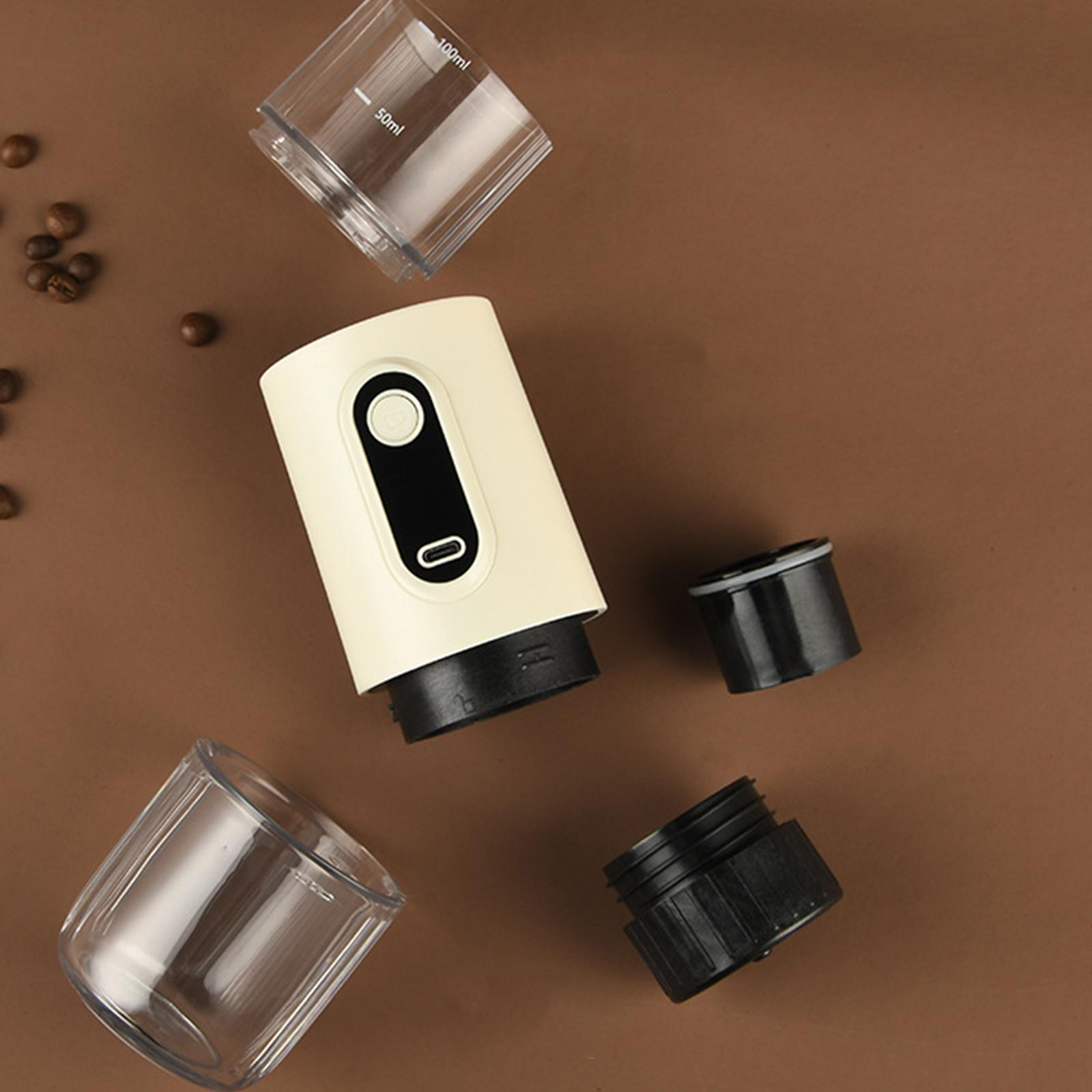 Eine Kaffeemaschine zerlegt. Auf einer braunen Oberfläche liegen mehrere Teile, darunter Behälter und Kaffeepulver.