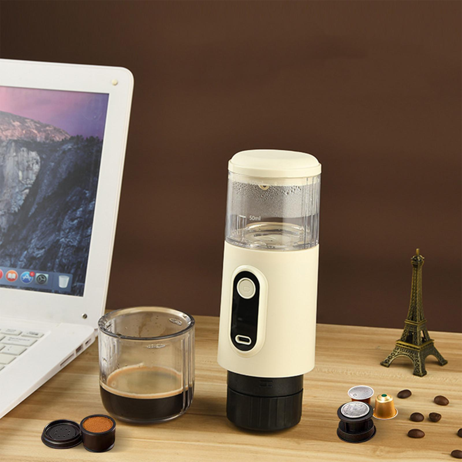Eine Kaffeemaschine mit mehreren Zubehörteilen. Ein Laptop und ein Miniatur-Eiffelturm sind im Hintergrund.