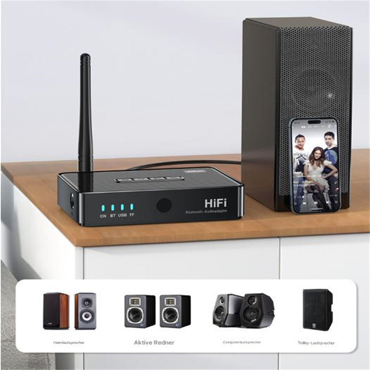 Ein schwarzer Audioadapter mit Antenne und mehreren Lautsprechern. Ein Telefon zeigt einen Videoanruf.