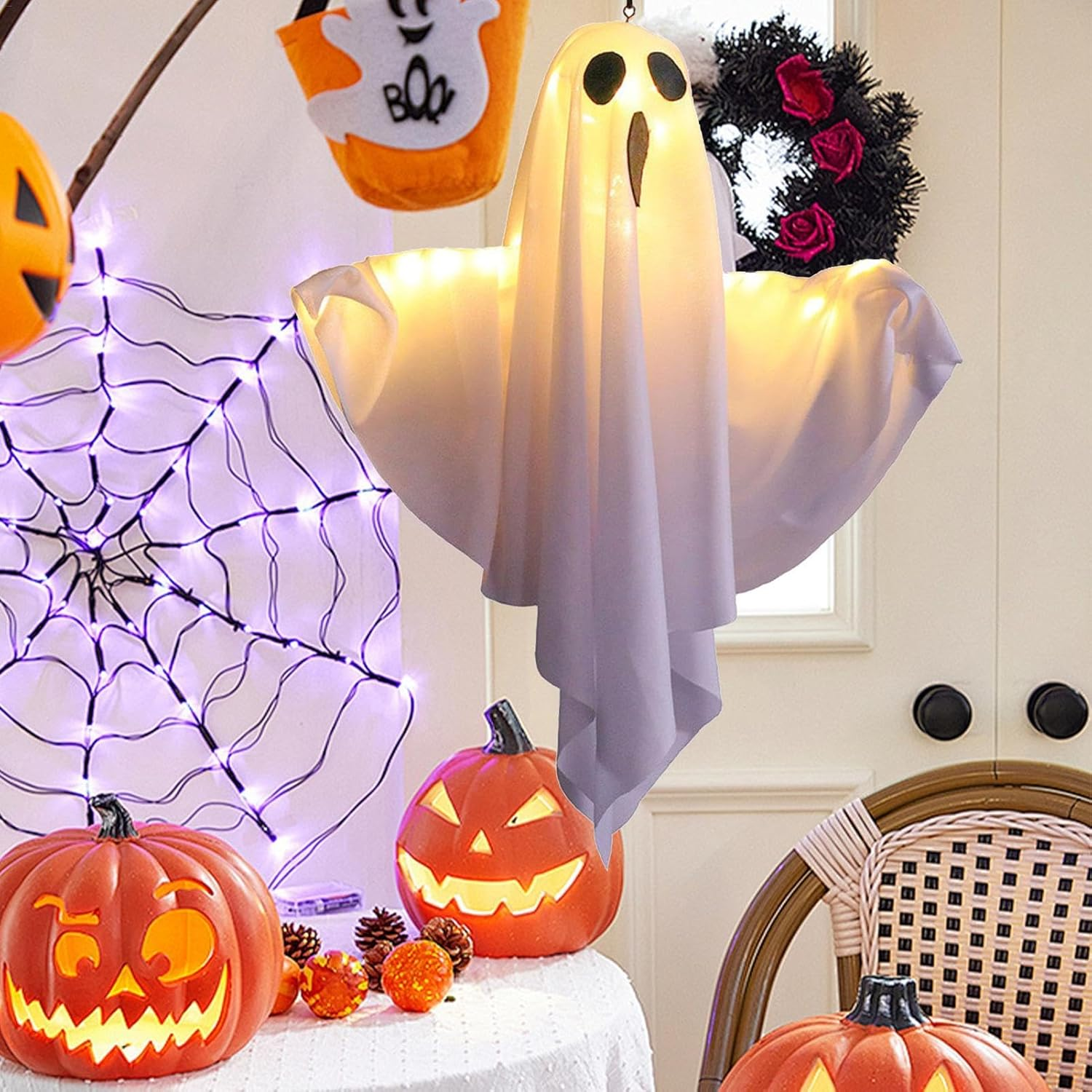 Eine Halloween-Szene mit einer weißen Geisterdekoration, Kürbissen und anderen Dekorationen. Eine gruselige und festliche Szene.