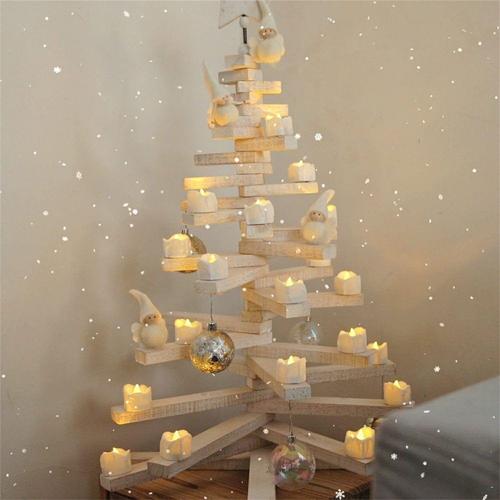Weihnachtsbaum aus Holz mit Kerzen und Dekorationen. Schneeflocken fallen im Hintergrund. Weiße Wand.