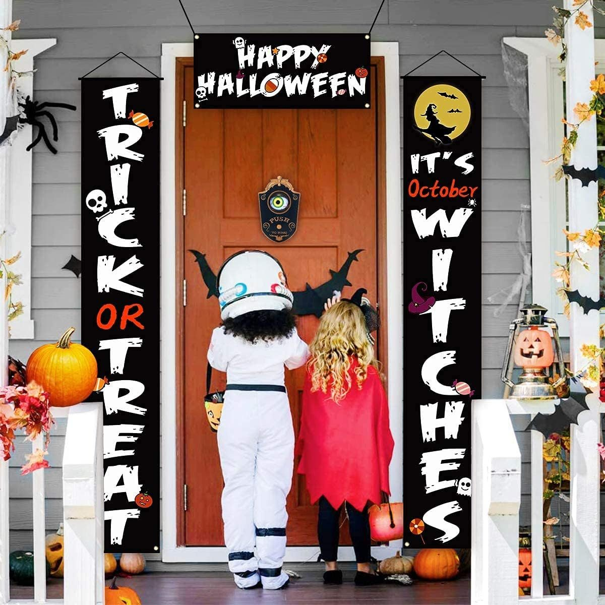 Kinder in Kostümen stehen vor einer Tür mit Halloween-Dekorationen.