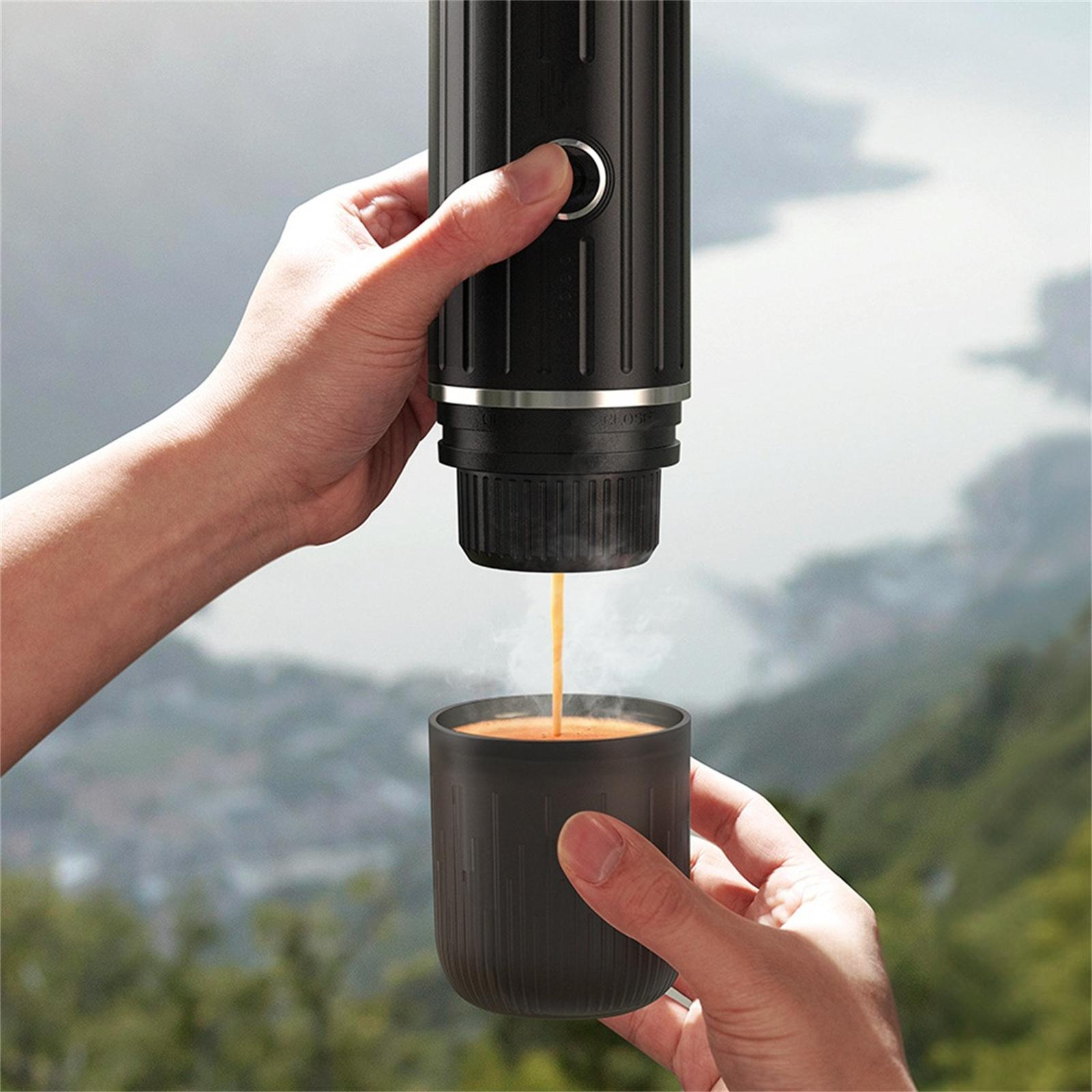Hände, die einen schwarzen tragbaren Espressomacher verwenden, um Kaffee in eine Tasse zu gießen, Szene im Freien.