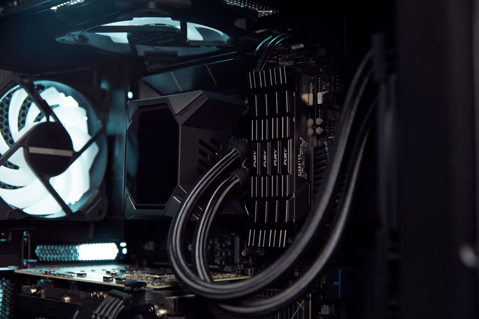 Wnętrze obudowy komputera pokazujące chłodnicę procesora, wentylator i komponenty.