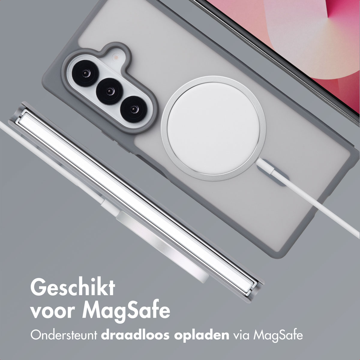 Een telefoon in een grijze hoes, met een draadloze oplader en een telefoonhoes, op een grijs oppervlak.