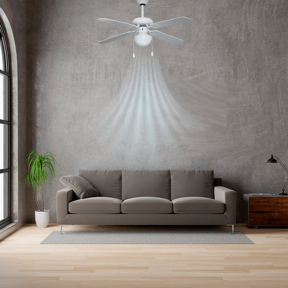 Un ventilador de techo blanco con luz. Un sofá gris y una planta frente a una pared gris. Suelo de madera.