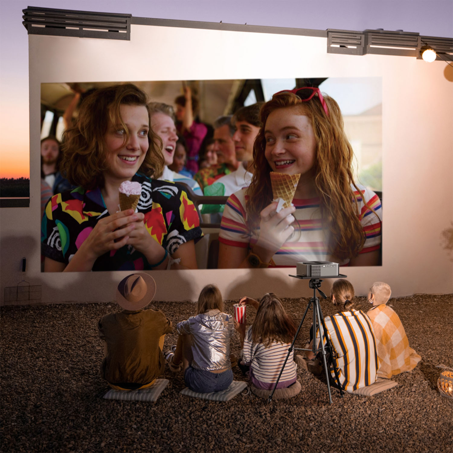 Ludzie oglądają film wyświetlany na ekranie. Scena obejmuje projektor, siedzących ludzi i obrazy uśmiechniętych aktorów.