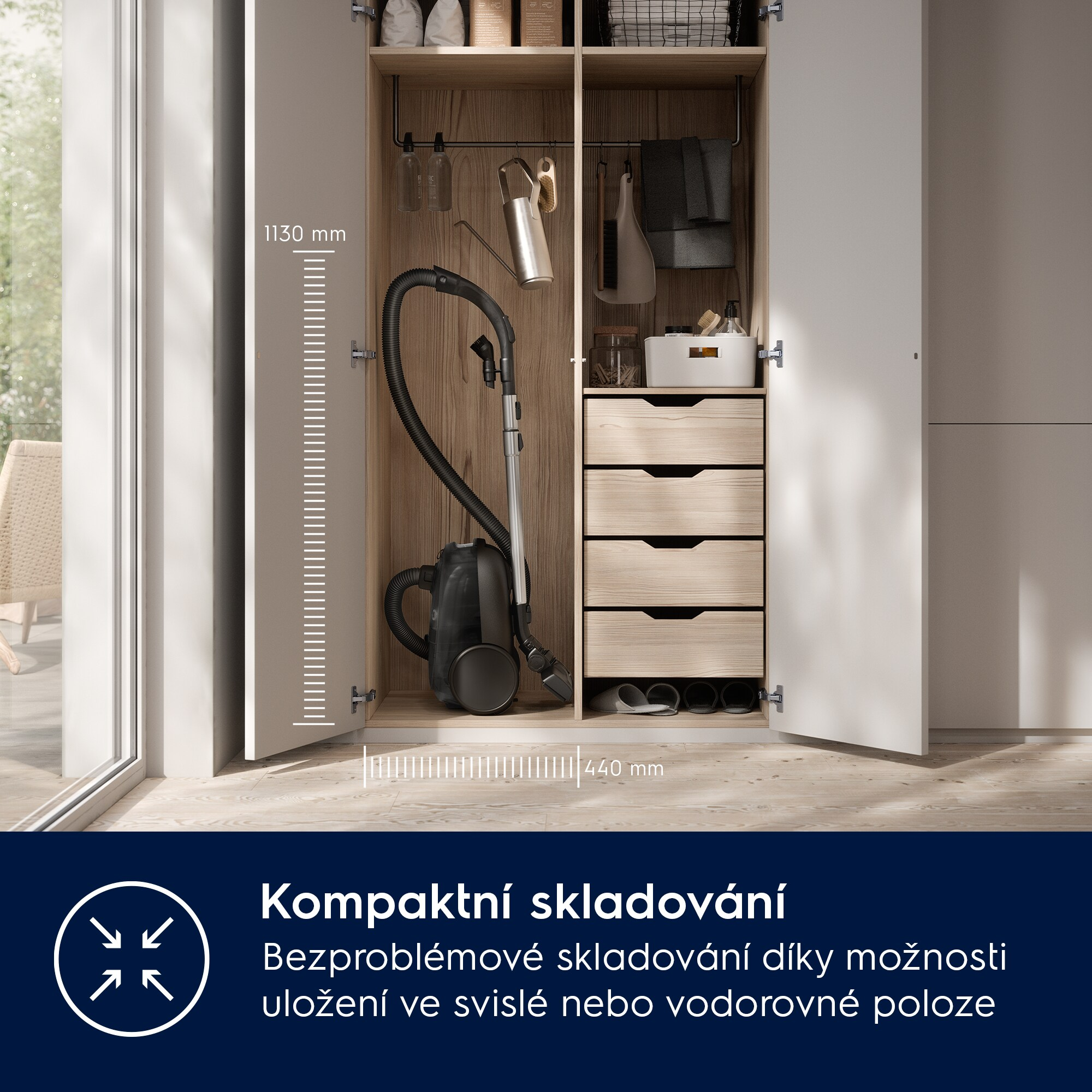 Un armadio bianco aperto con un aspirapolvere nero all'interno. Sono visibili cassetti e ripiani.