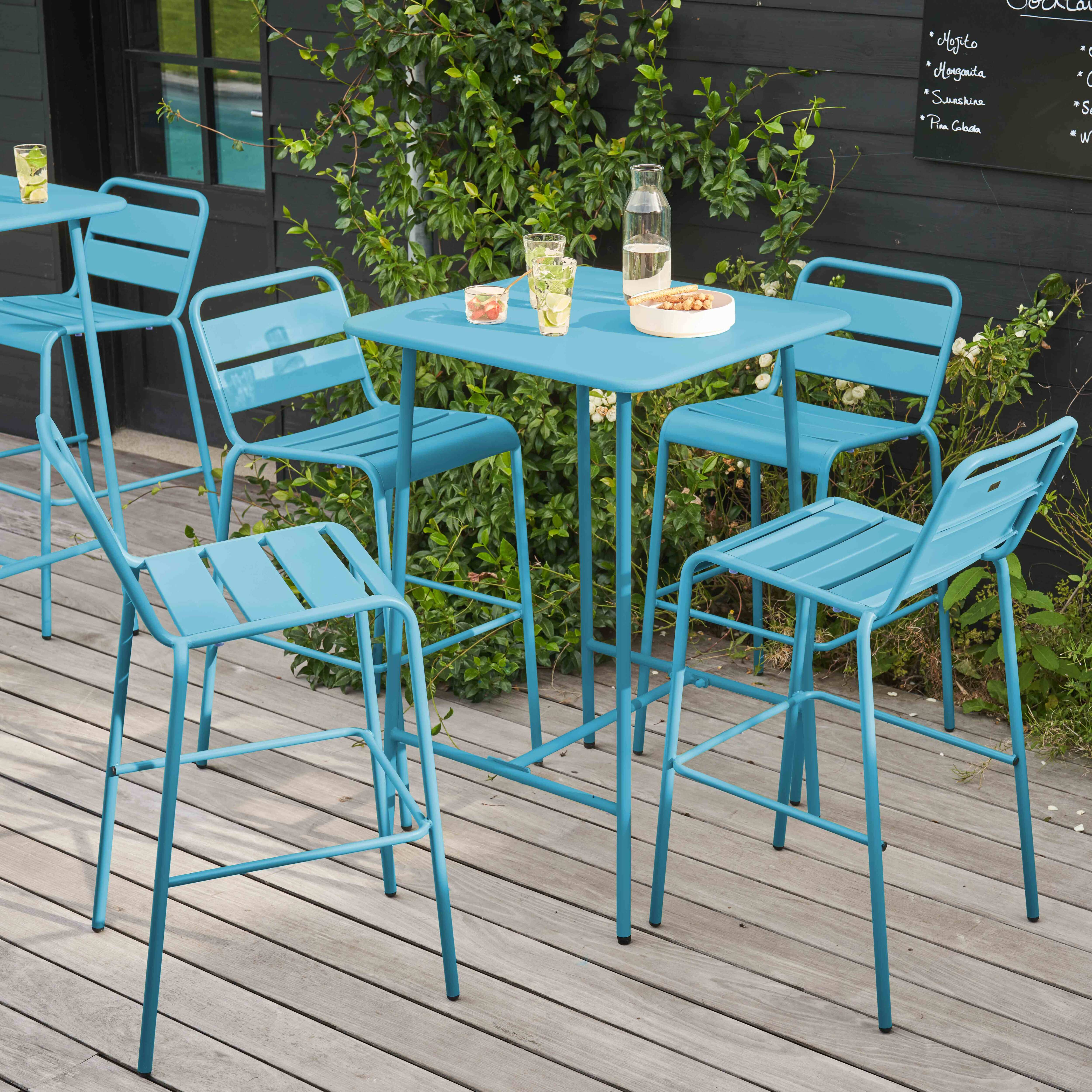Szene eines Straßencafés. Blaue Metalltische und Stühle auf einem Holzdeck. Hintergrund ist eine Wand.