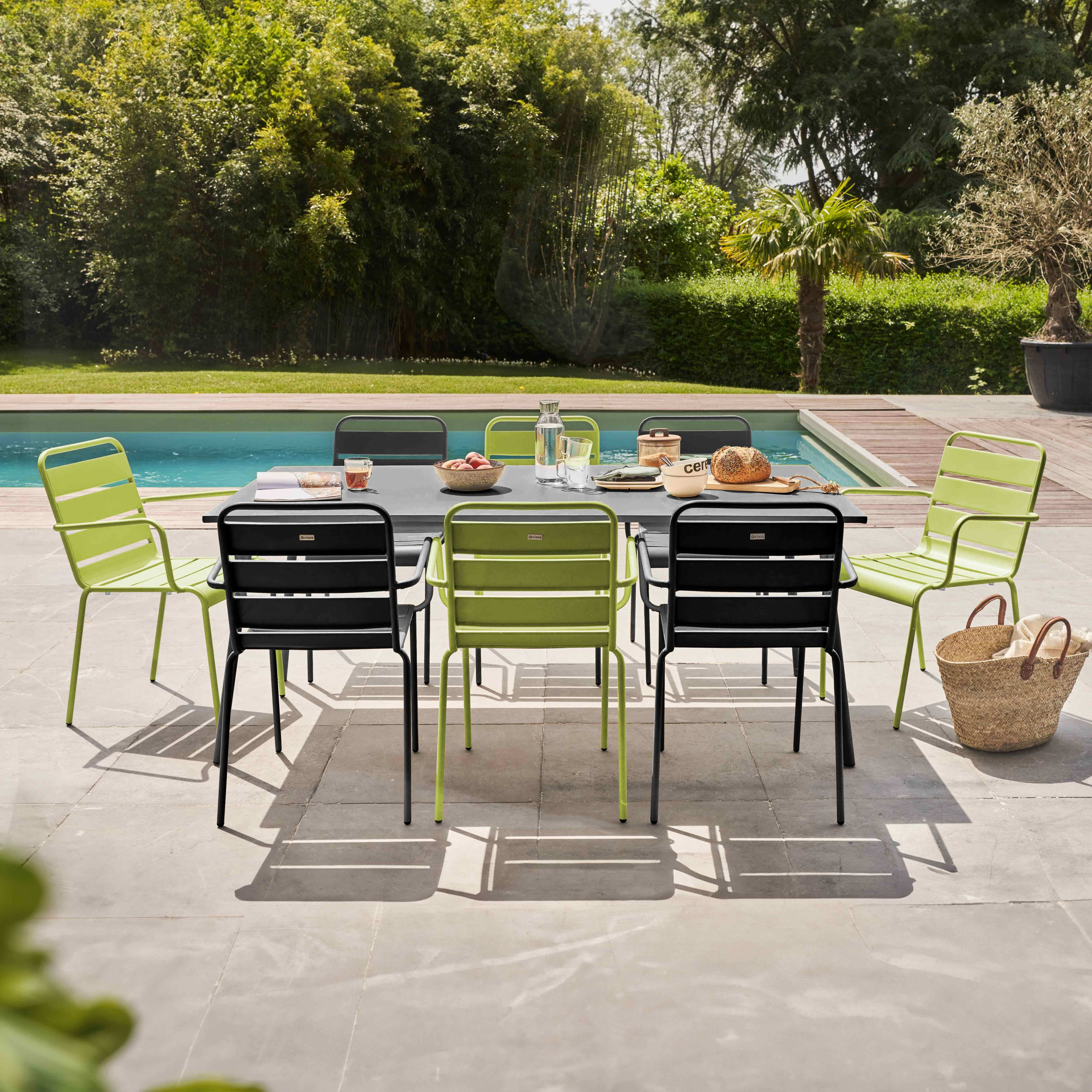 Terrassenmöbel mit Tisch, Stühlen und Essen, in der Nähe eines Pools.