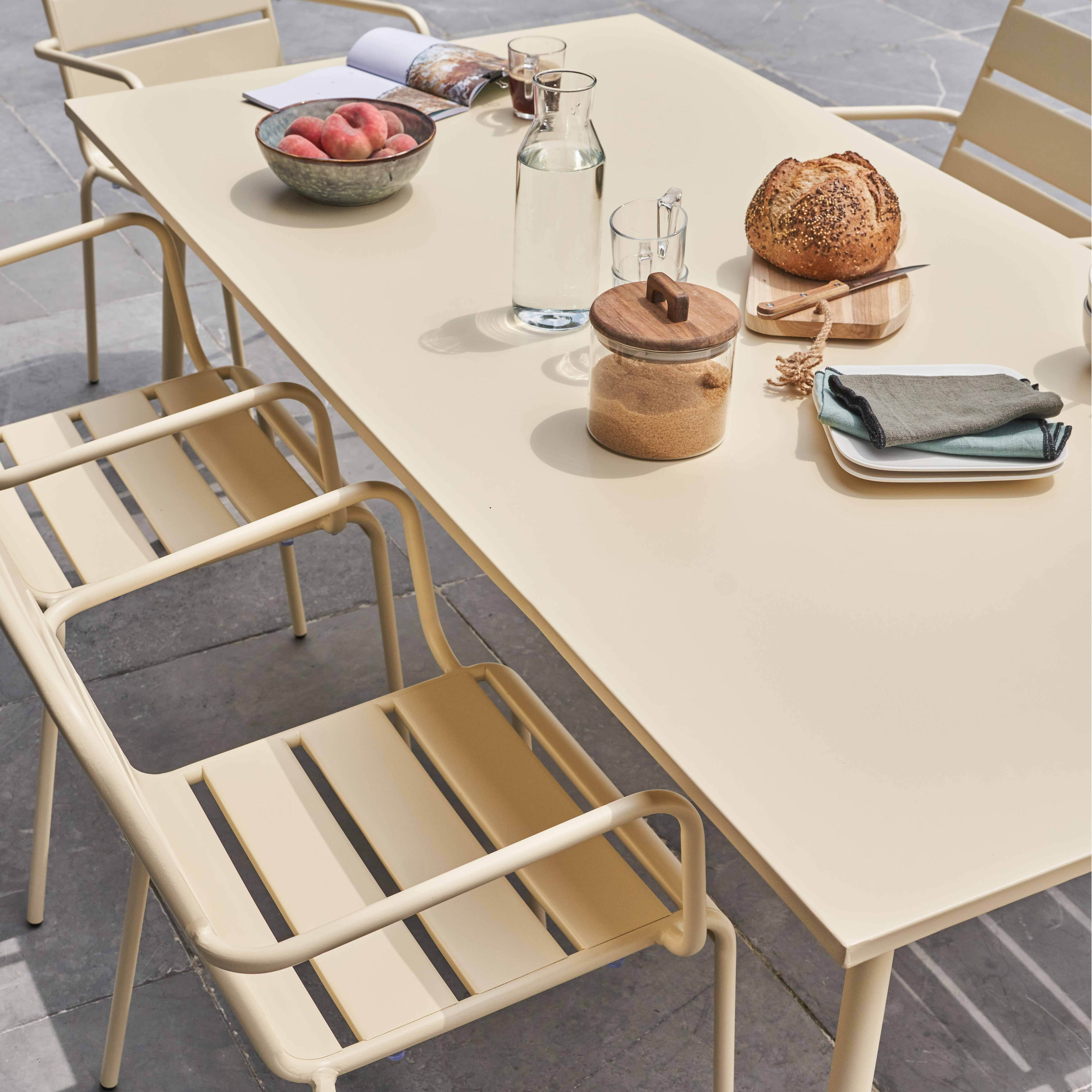 Ein Esstisch mit Essen, Gläsern und Stühlen. Der Tisch ist beige und hat eine rechteckige Form.