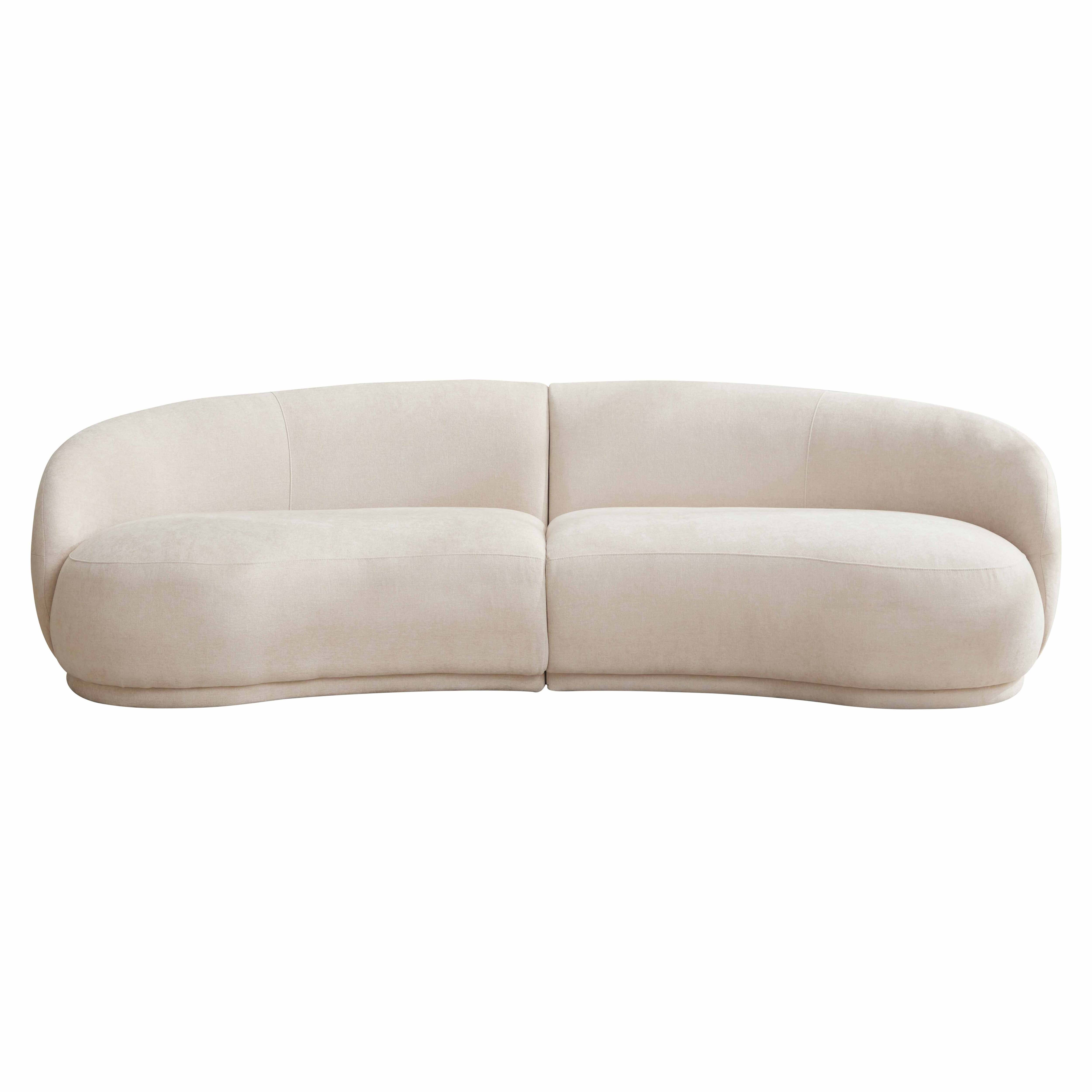 Ein cremefarbenes, geschwungenes Sofa auf weißem Hintergrund.