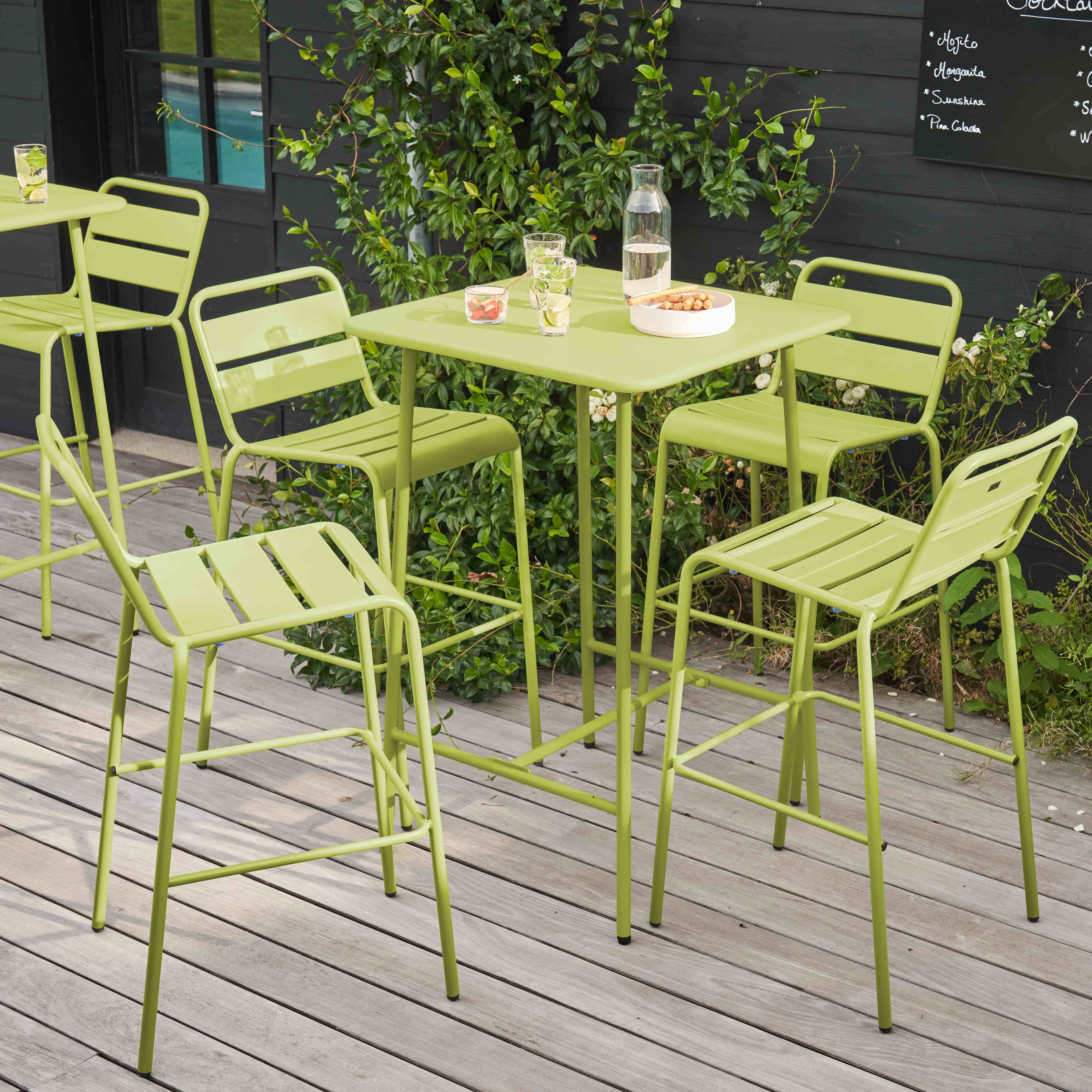 Limettengrüne Szene im Freien. Ein Tisch und Stühle stehen auf einer Holzterrasse. Schwarze Menütafel sichtbar.