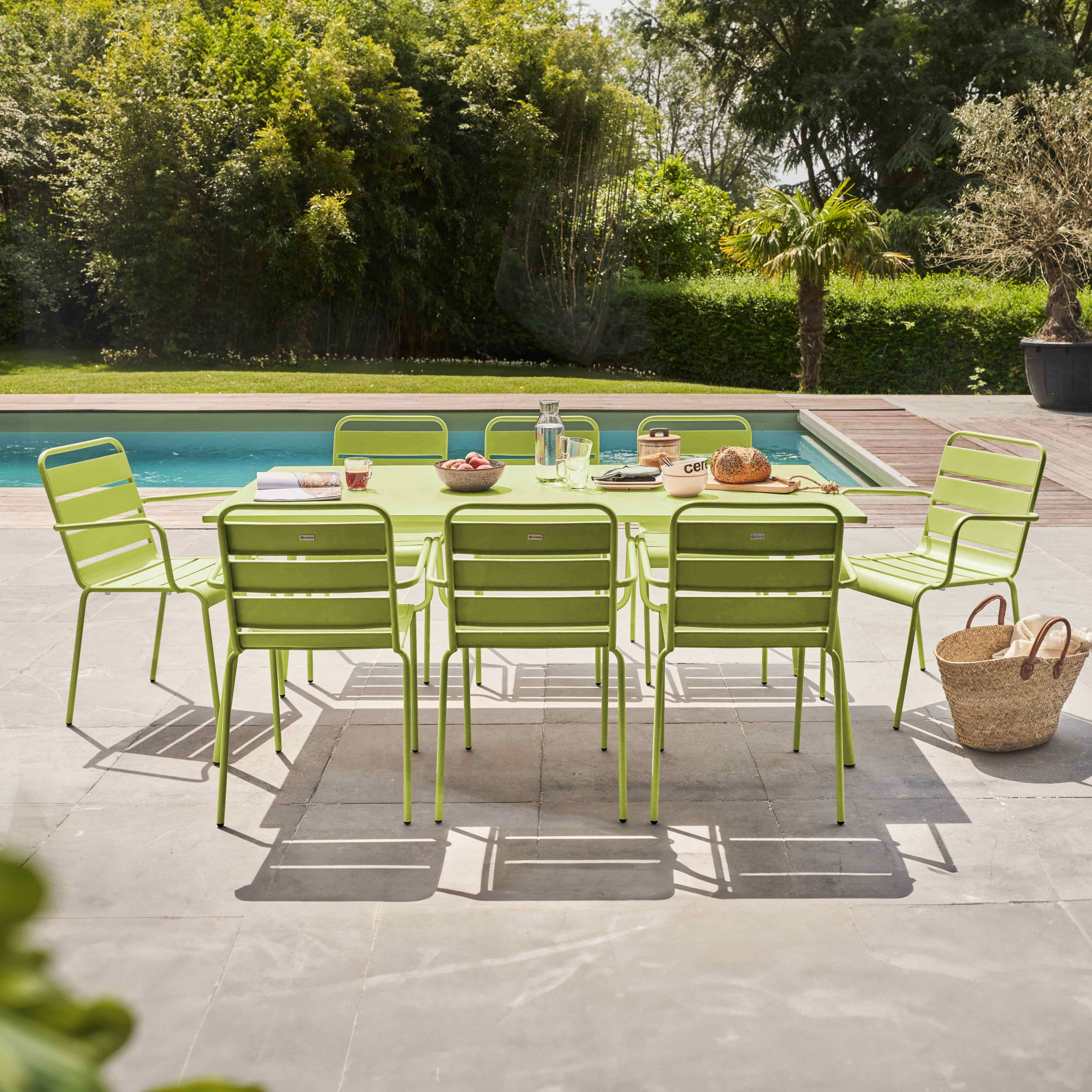 Ein limettengrüner Terrassentisch und Stühle stehen auf einer Steinterrasse.