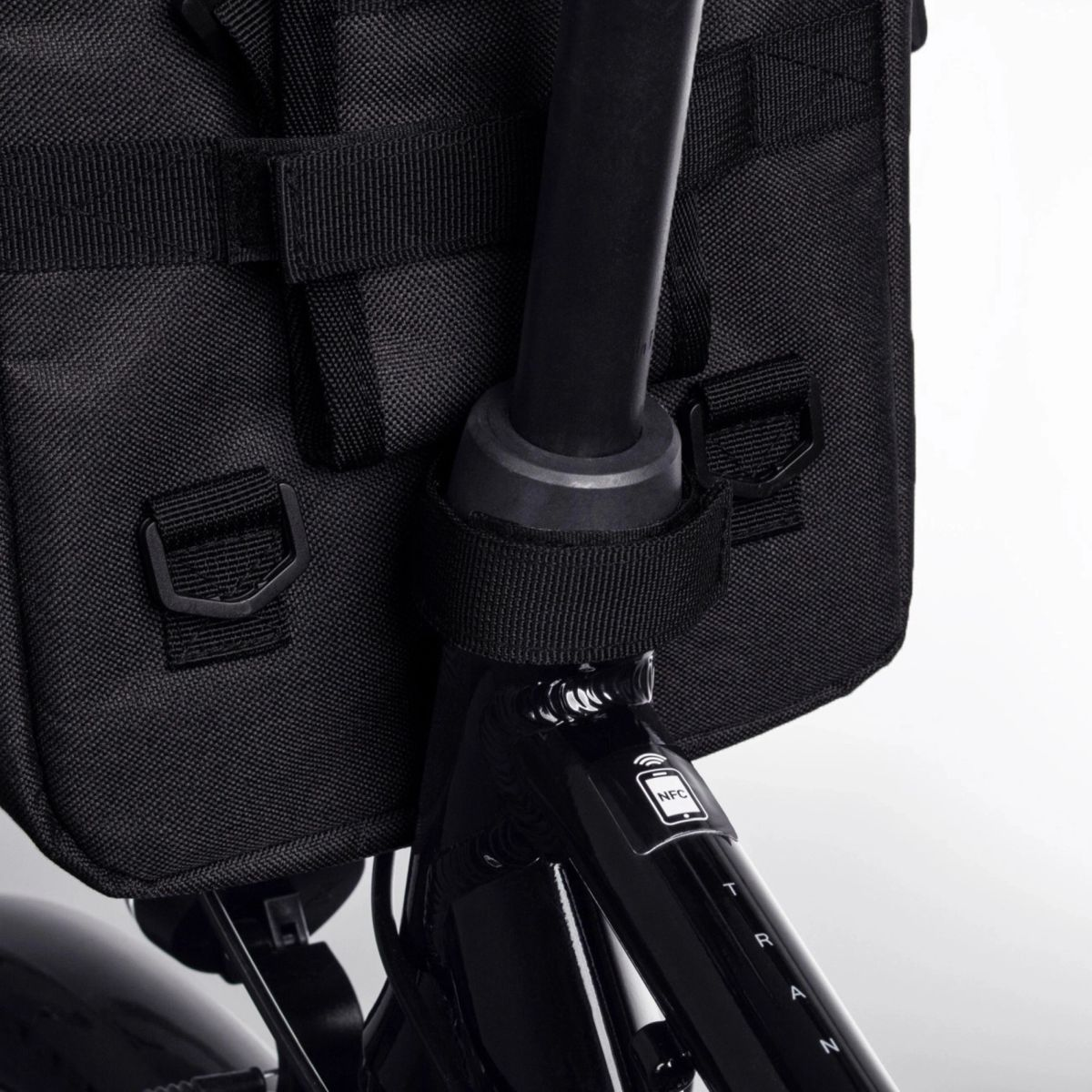 Czarna torba rowerowa przymocowana do sztycy siodełka roweru.