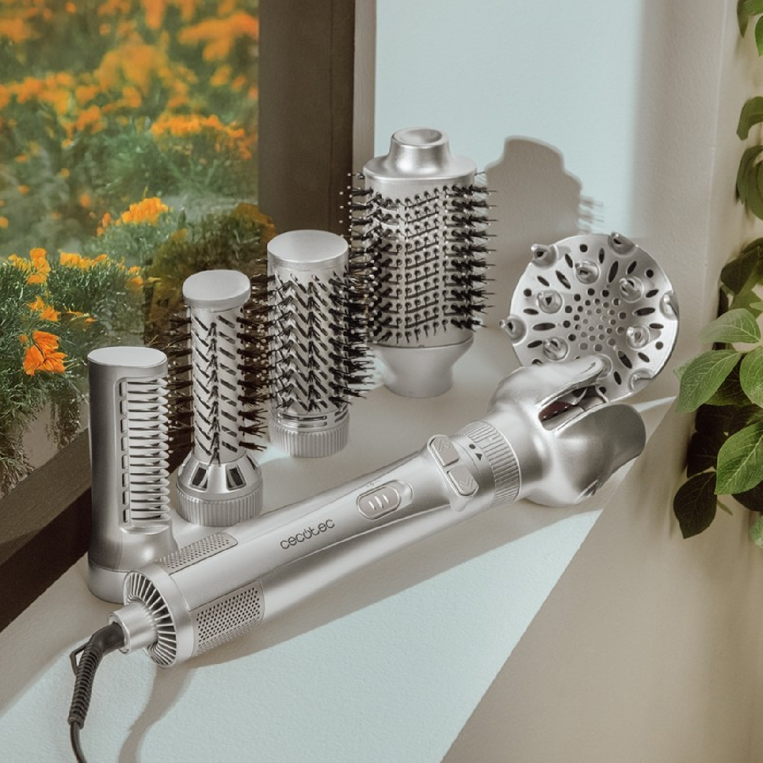 Strumenti per lo styling dei capelli su un davanzale. Include un asciugacapelli e accessori.