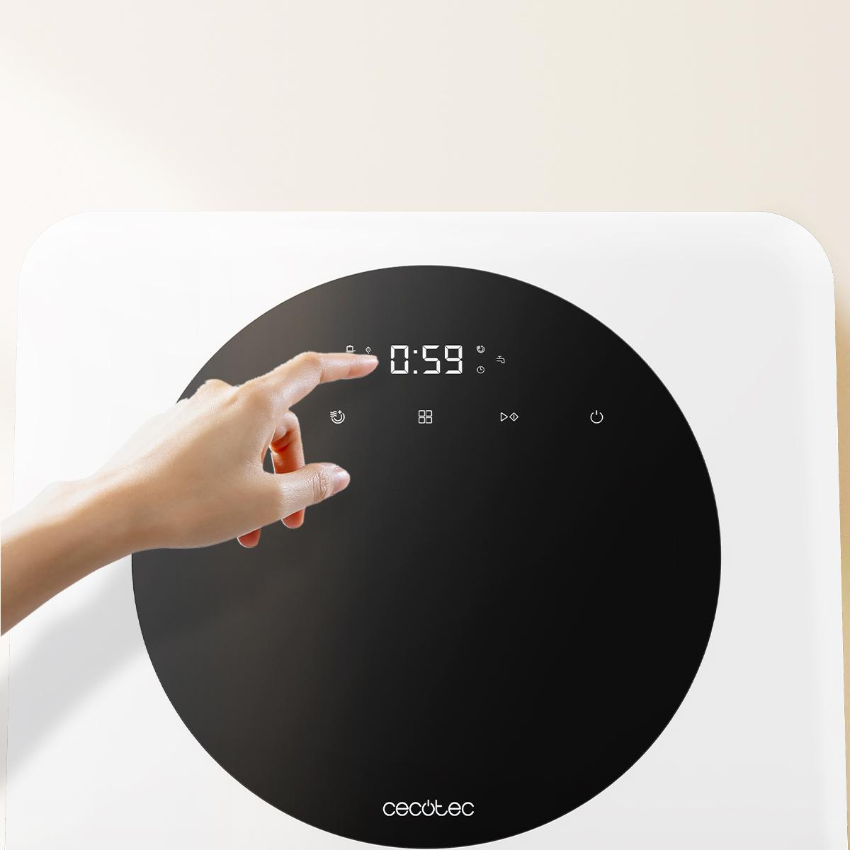 La mano de una persona tocando un electrodoméstico blanco con una pantalla circular negra que muestra 0:59.
