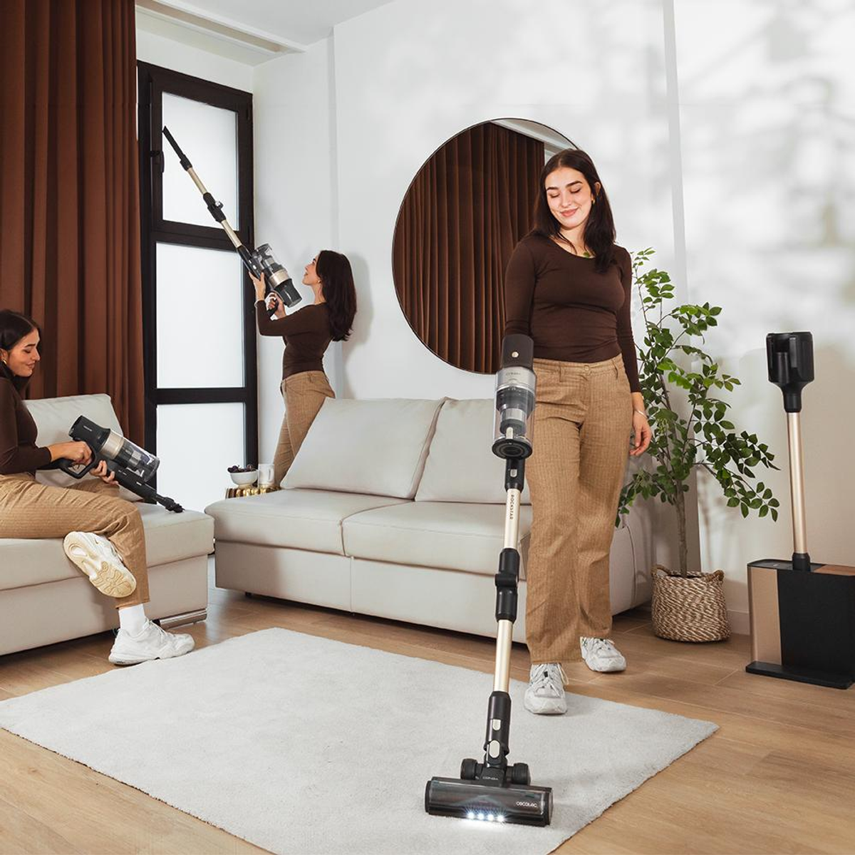 A woman using a cordless vacuum cleaner in a room with a mirror.