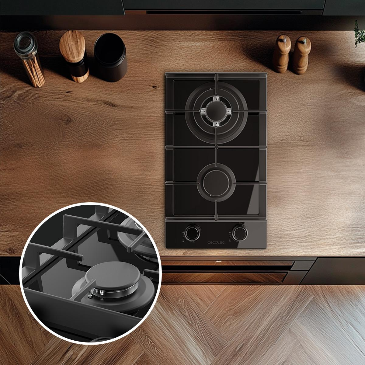 Piano cottura nero su un piano di lavoro in legno. Manopole e dettagli del bruciatore visibili.
