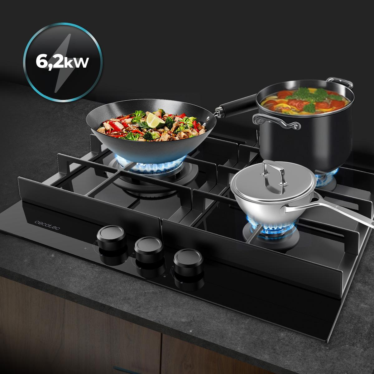 Czarna płyta grzewcza z trzema garnkami. Jest wok z jedzeniem, garnek z zupą i mały garnek. Tekst mówi 6,2 kW.