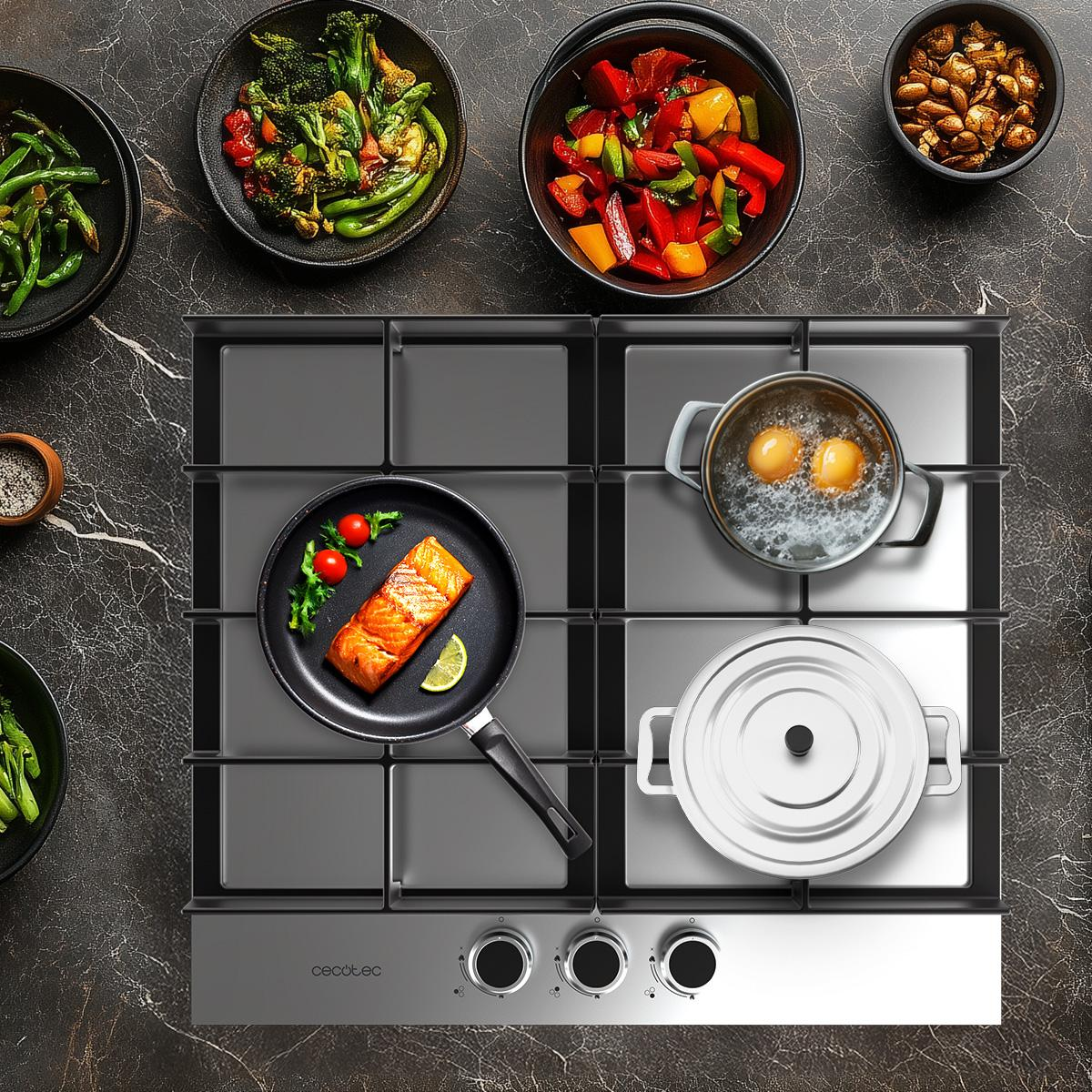 Płyta ze stali nierdzewnej z jedzeniem. Łosoś, warzywa i garnki. Marmurowe tło.