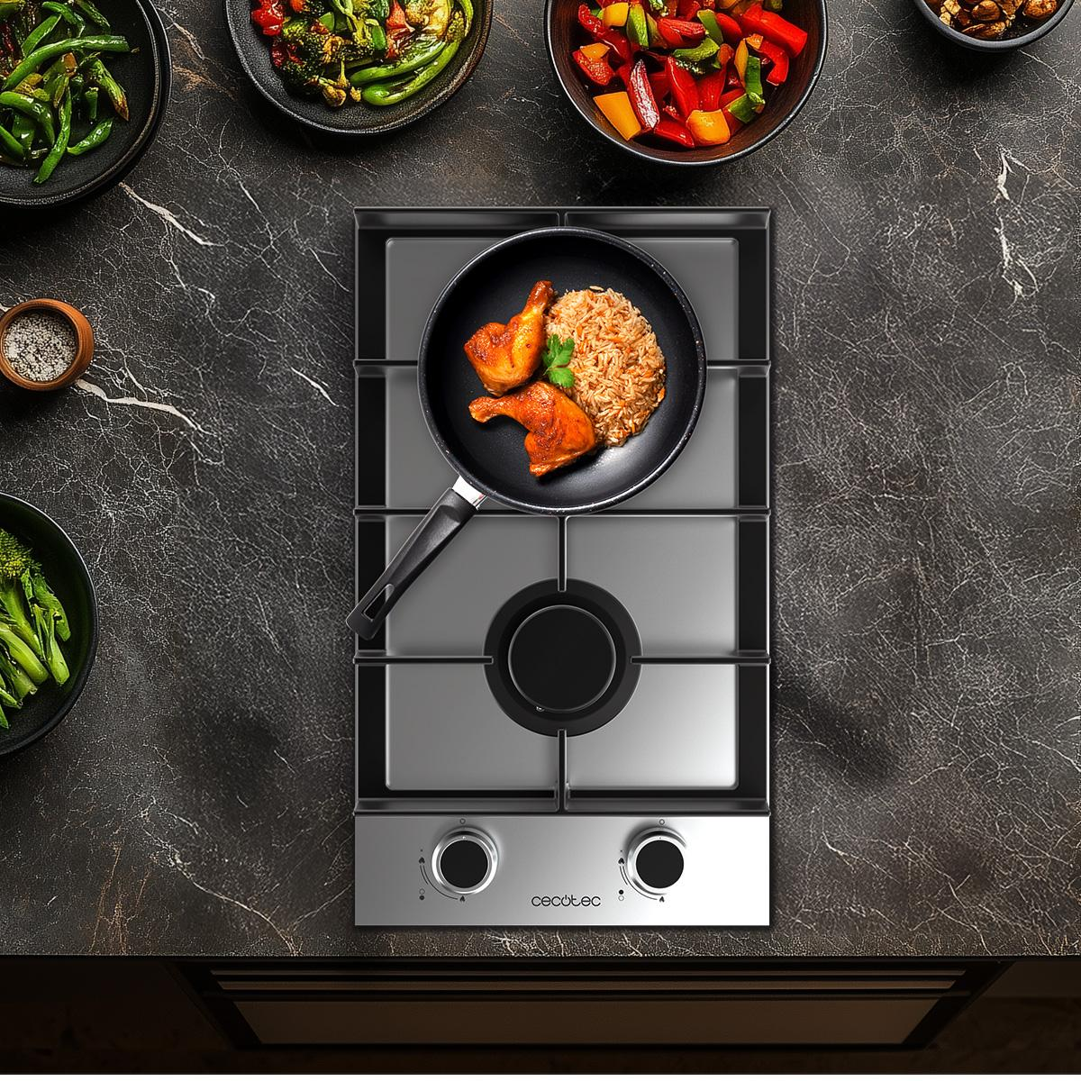 Widok z góry na płytę kuchenną z patelnią zawierającą kurczaka i ryż.