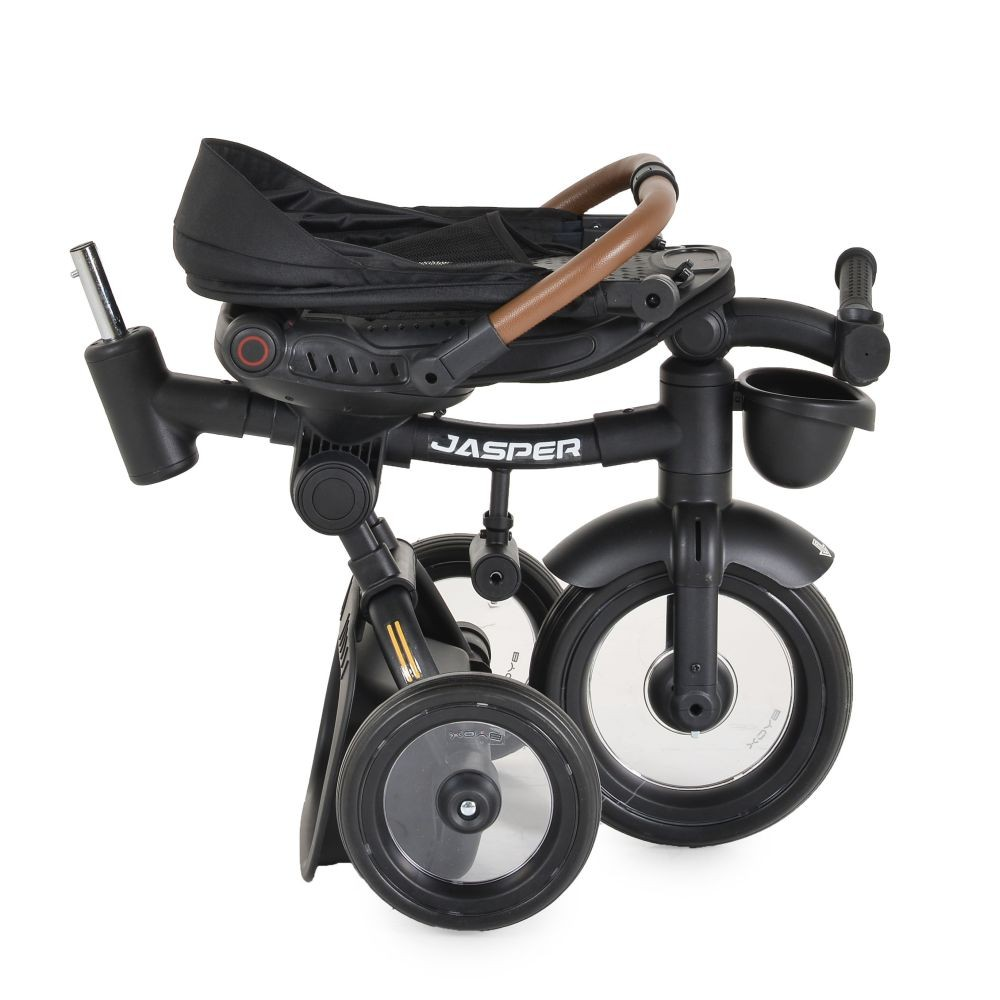 Un triciclo negro plegado. El asiento es negro, las ruedas son beige y tiene la palabra 'JASPER'.