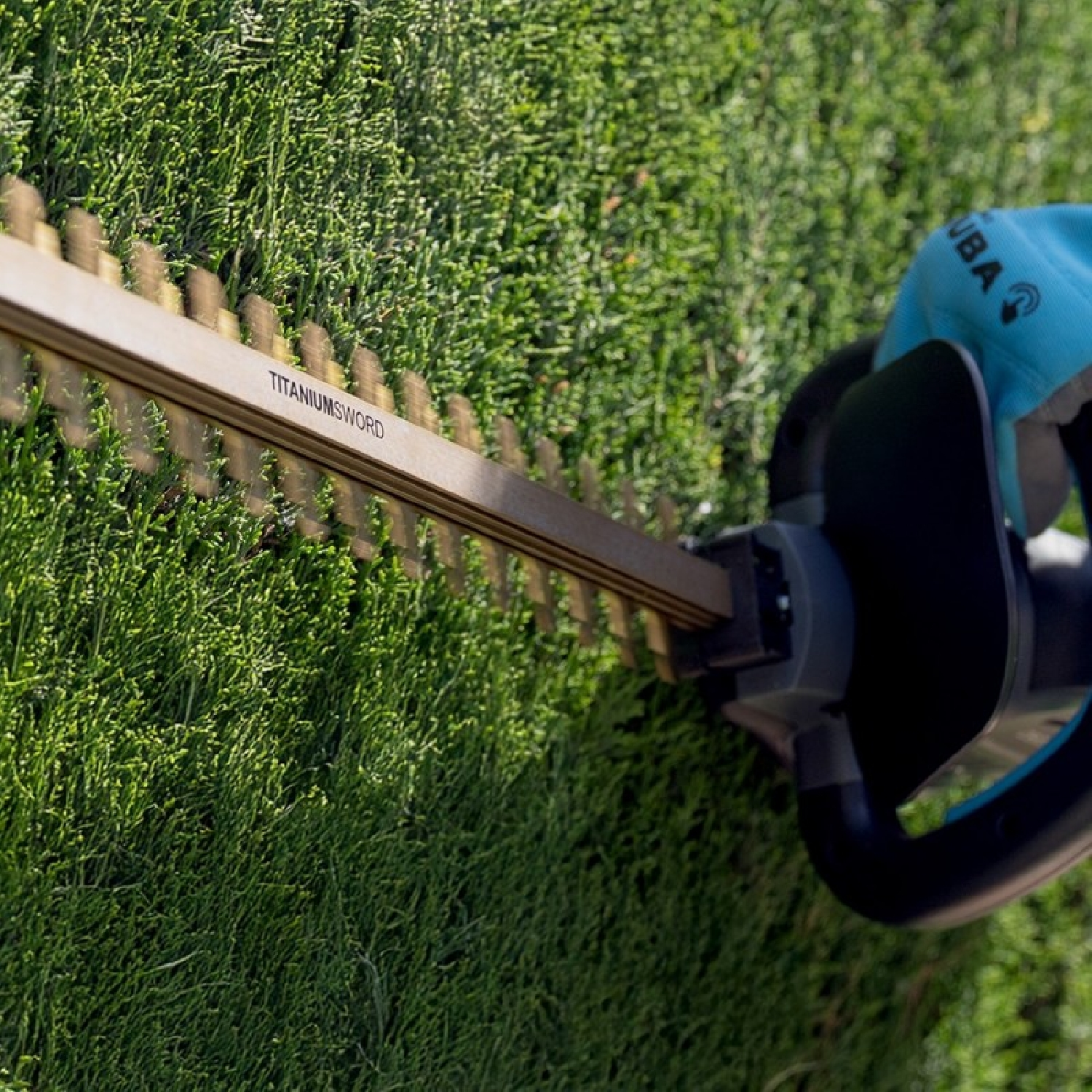 Primer plano de la cuchilla de un cortasetos cortando follaje verde en un jardín.