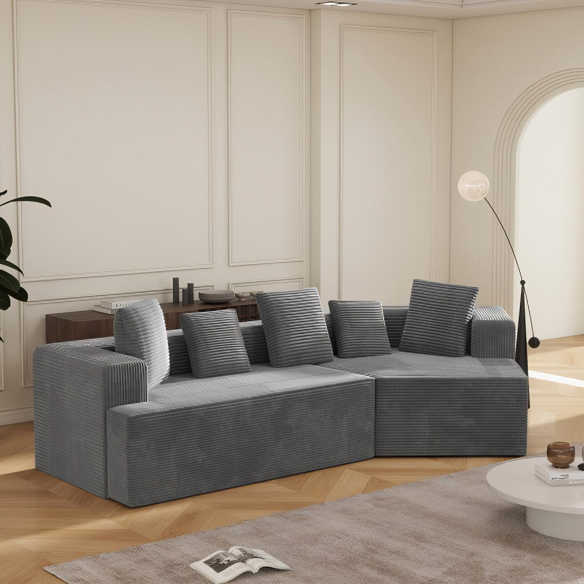 Graues Ecksofa mit Kissen in einem modernen Wohnzimmer mit weißem Boden und Wänden.
