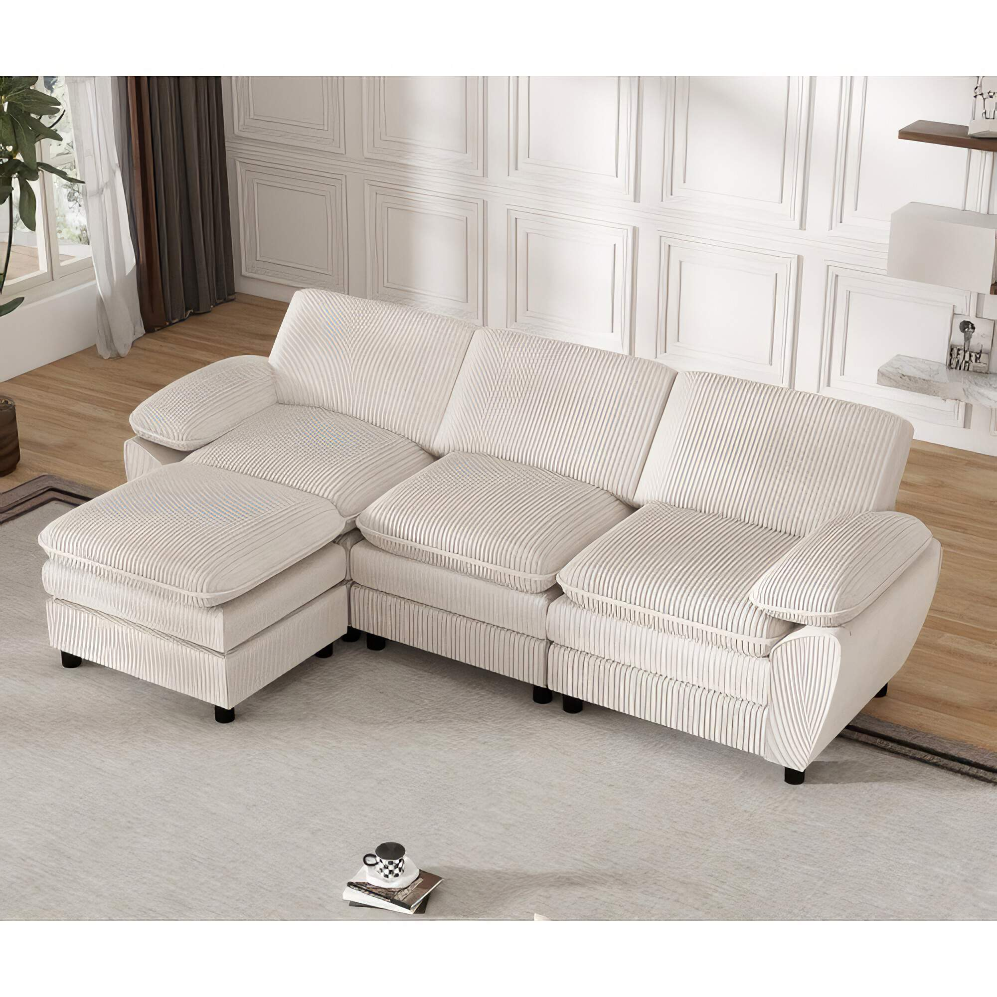 Cremefarbenes Ecksofa mit Chaiselongue. Es steht auf einem hellgrauen Teppich in einem Raum mit Fenster.