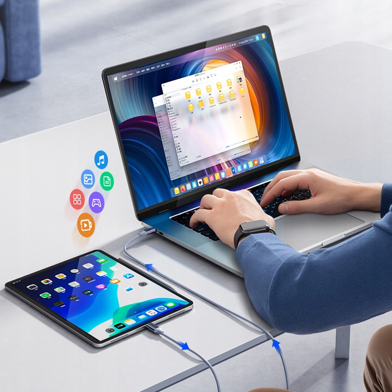 Laptop und Tablet mit Kabel verbunden, zeigt eine Dateiübertragungsoberfläche, auf weißem Tisch.