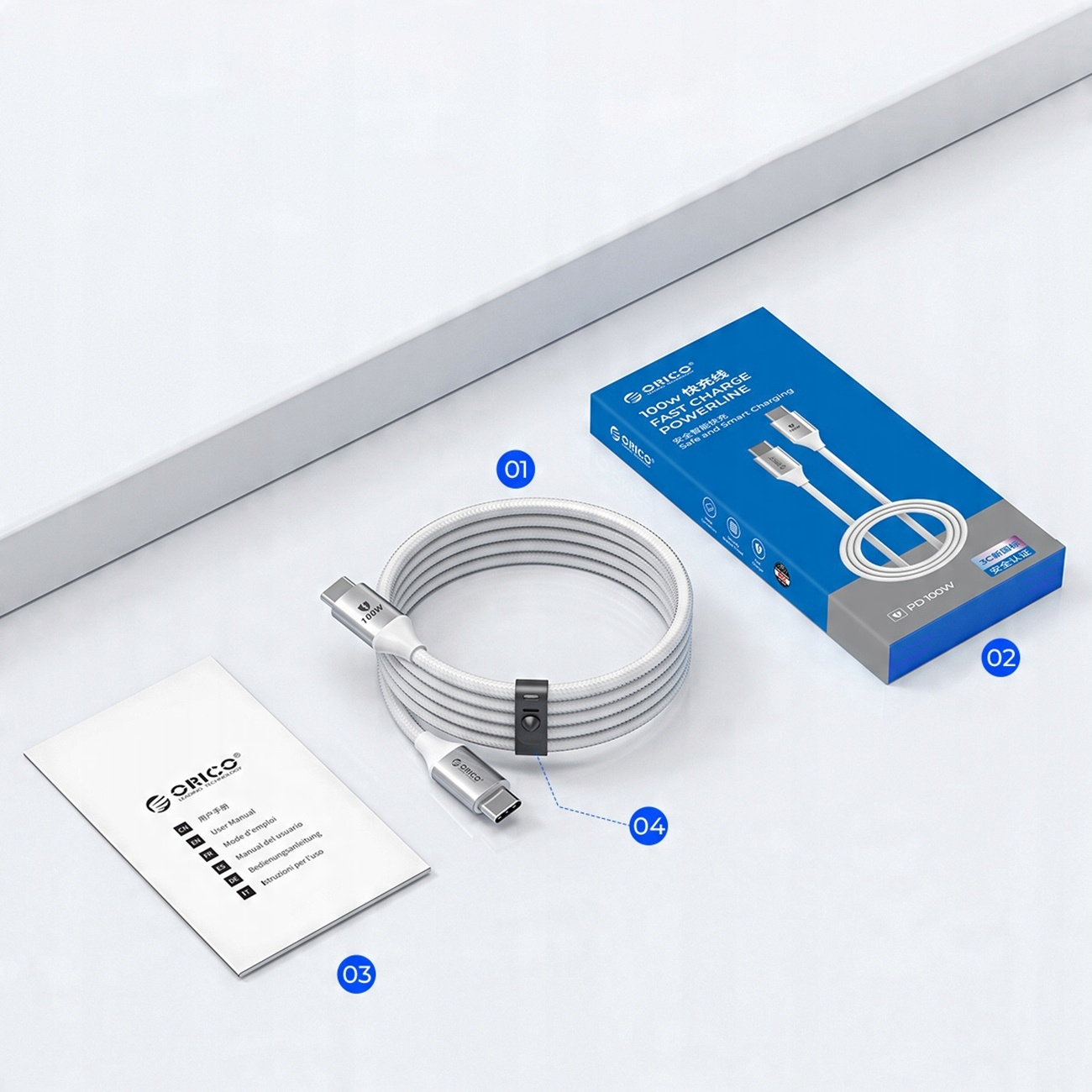 Weißes USB-C-Kabel, mit einer Box, einer Anleitung und einem schwarzen Kabelorganizer.