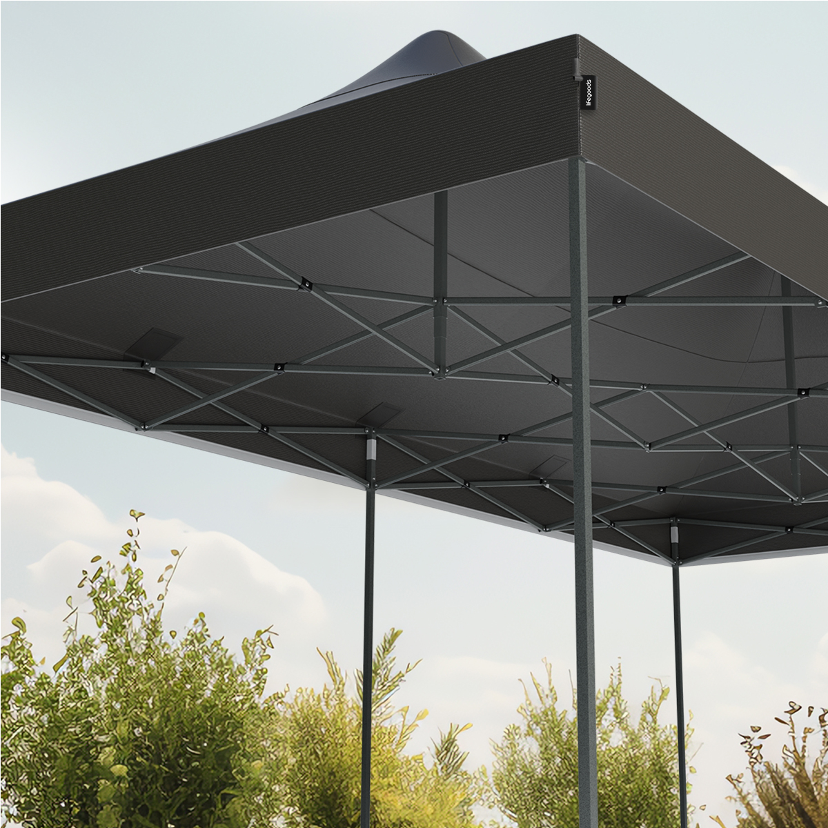 Close-up of a grey canopy tent, with green bushes in the foreground and a blue sky.