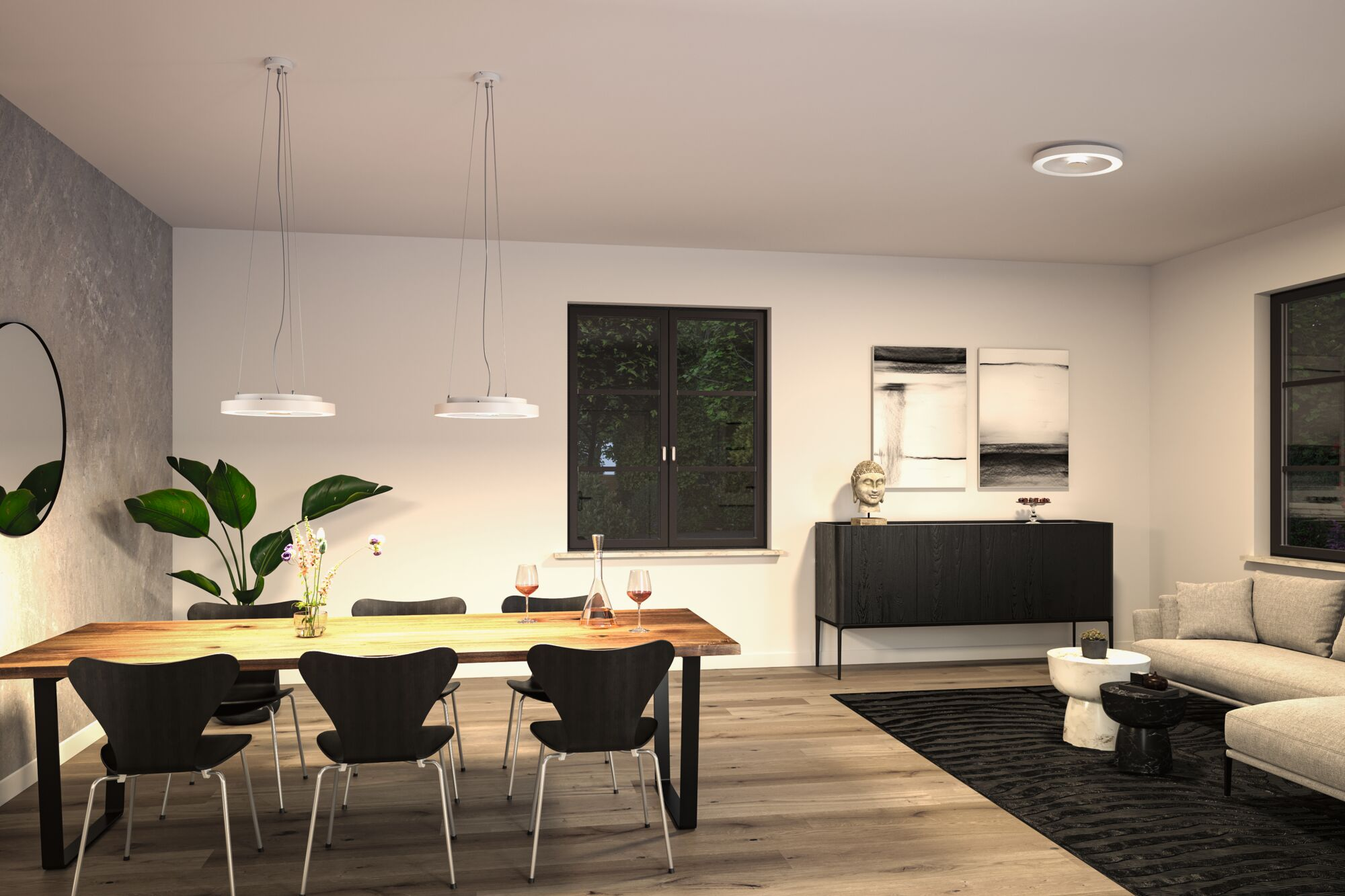 Esszimmer mit langem Holztisch, schwarzen Stühlen und Pendelleuchten. Hell, modern.