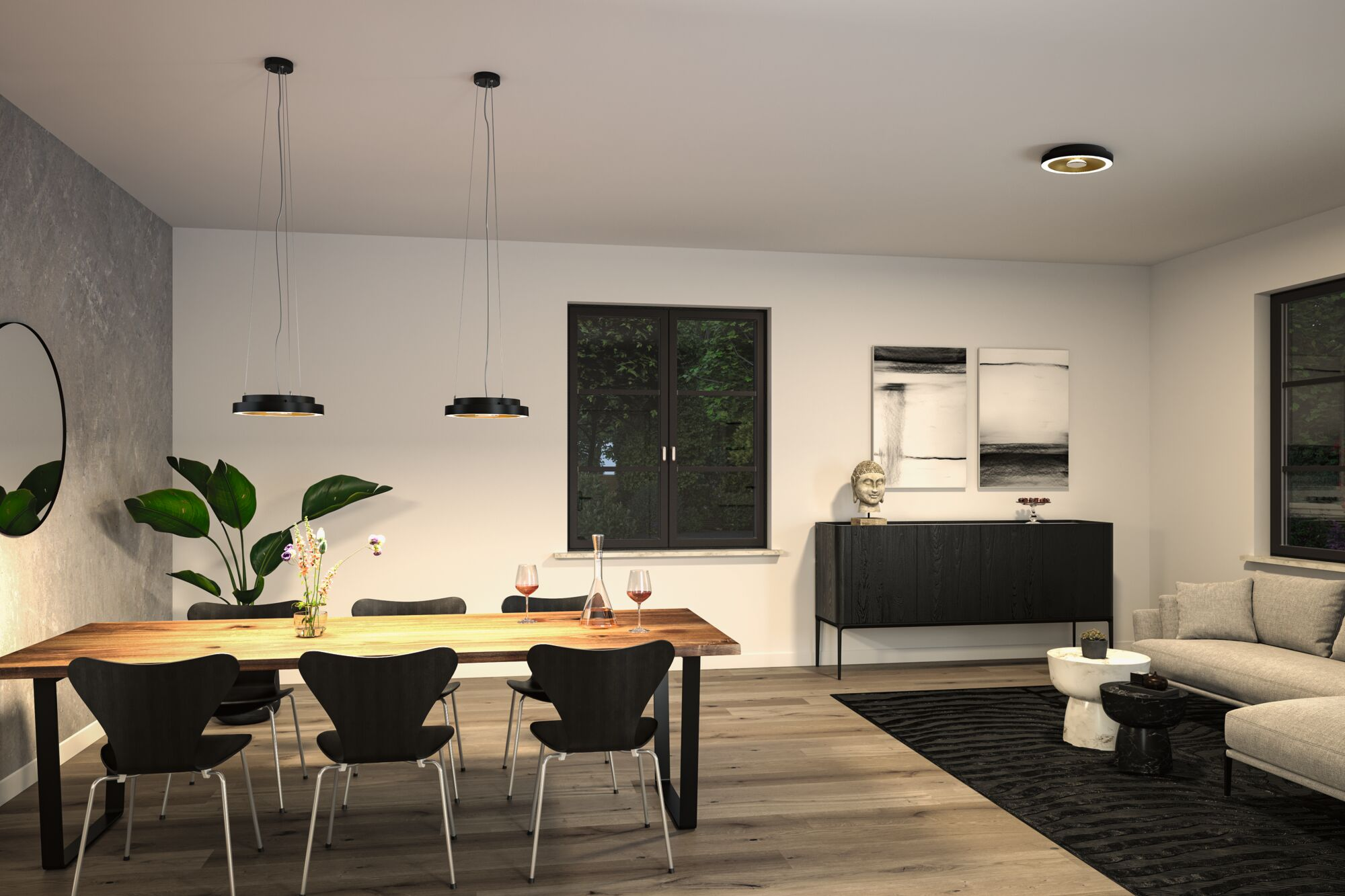 Esszimmer mit langem Holztisch, schwarzen Stühlen und schwarzem Schrank. Zwei Pendelleuchten.