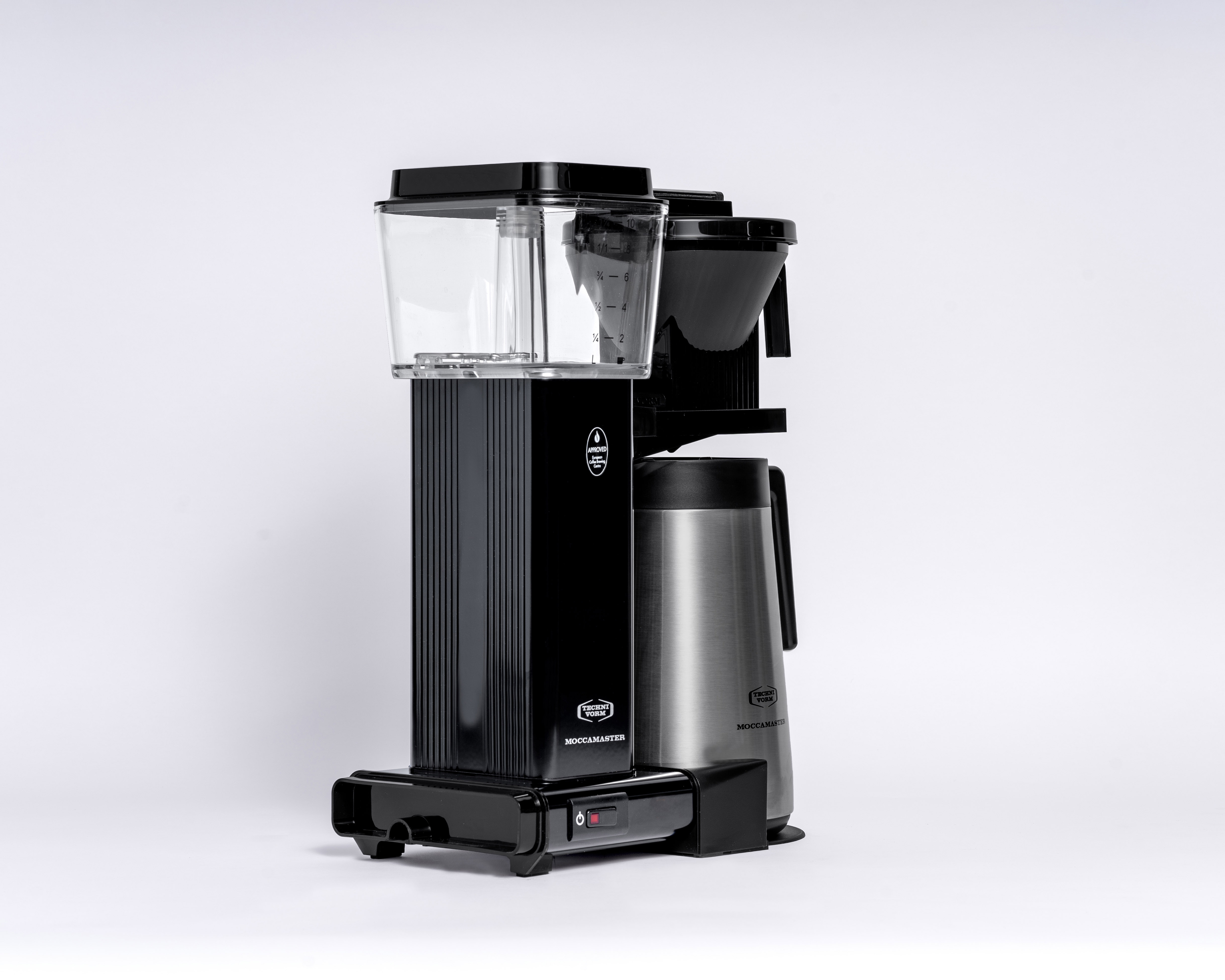 Czarny ekspres do kawy z karafką i przezroczystym zbiornikiem na wodę na białym tle. Widok z boku.