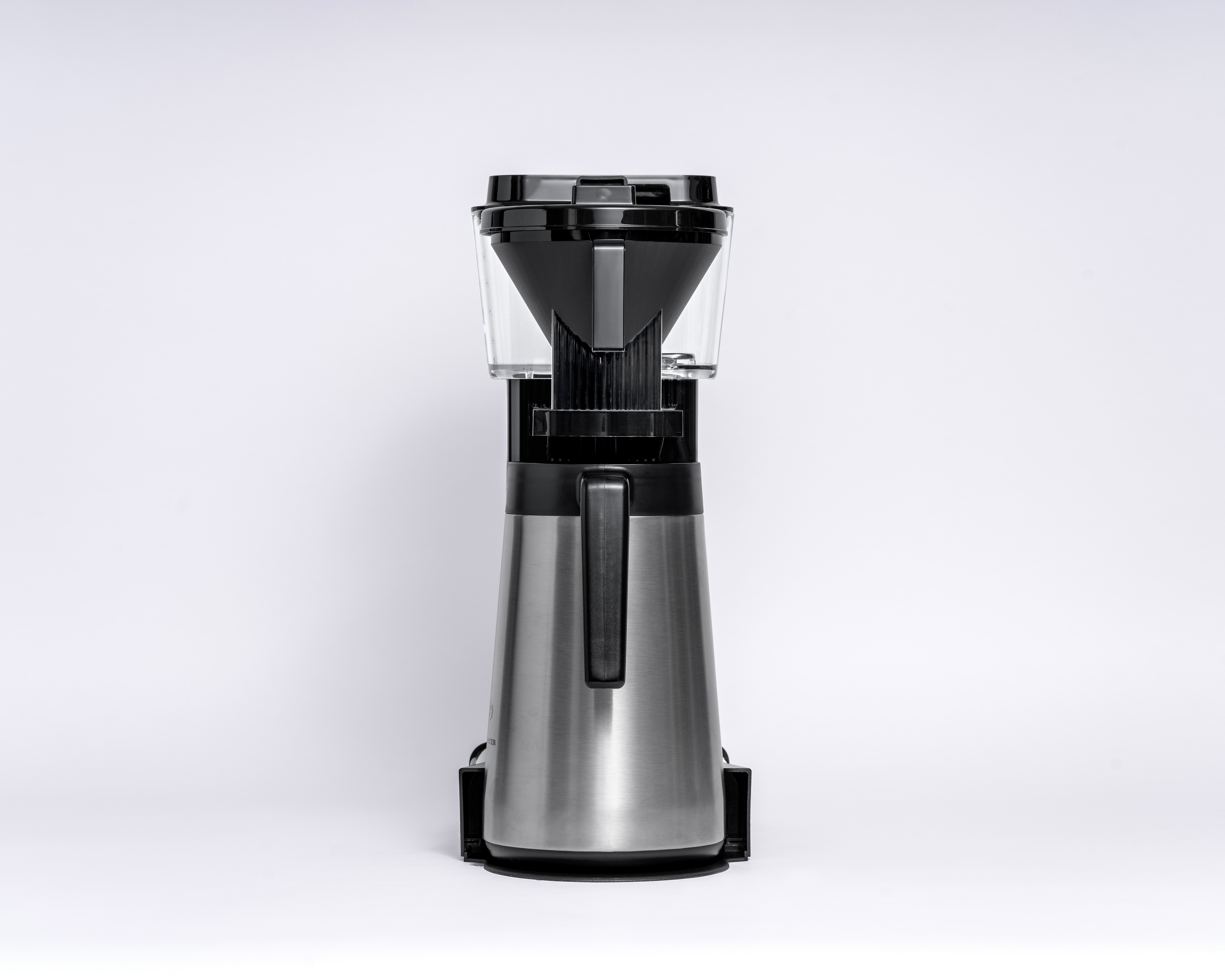 Srebrny ekspres do kawy z przezroczystym zbiornikiem na wodę i czarnym uchwytem. Widok z przodu, białe tło.