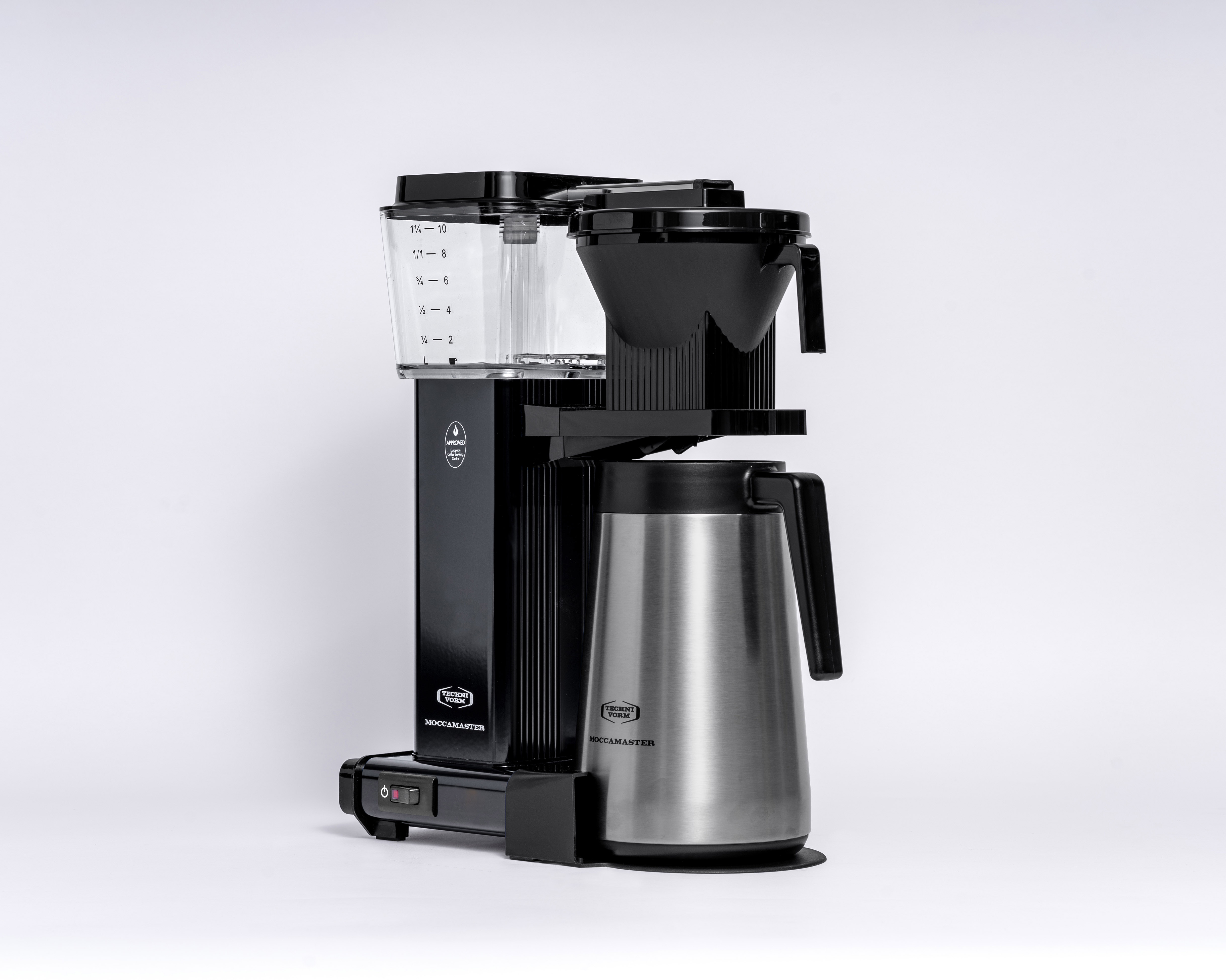 Czarny ekspres do kawy z karafką i przezroczystym zbiornikiem na wodę. Widok z boku, białe tło.